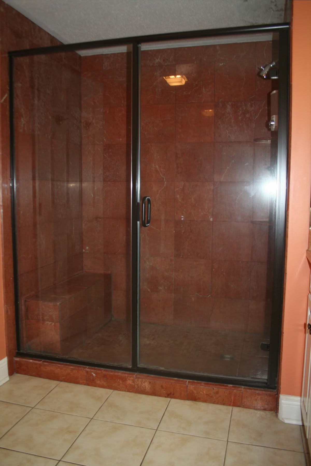 walk-in tiled shower with bench in master bathroom