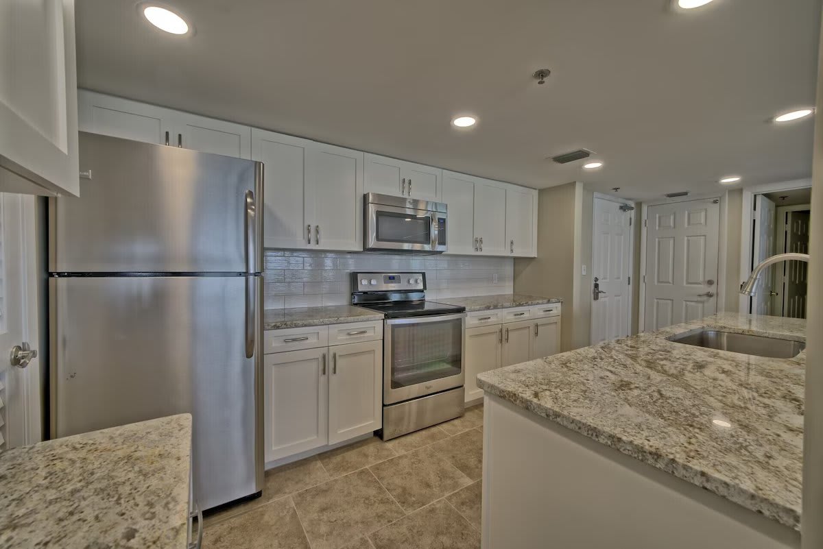 Newly renovated kitchen with granite, large sink, island bar seating, stainless