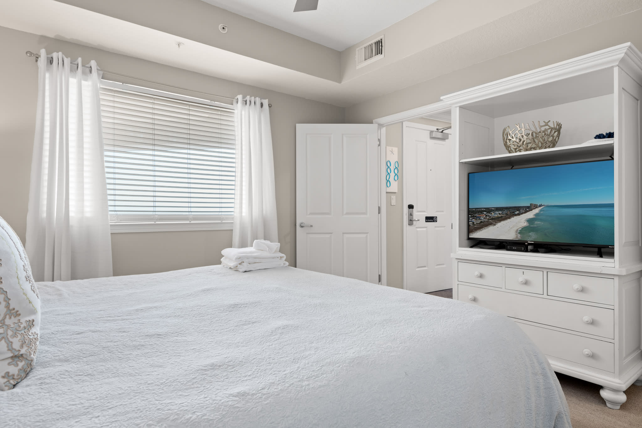 Bedroom w/ window light and TV, blending comfort and convenience.