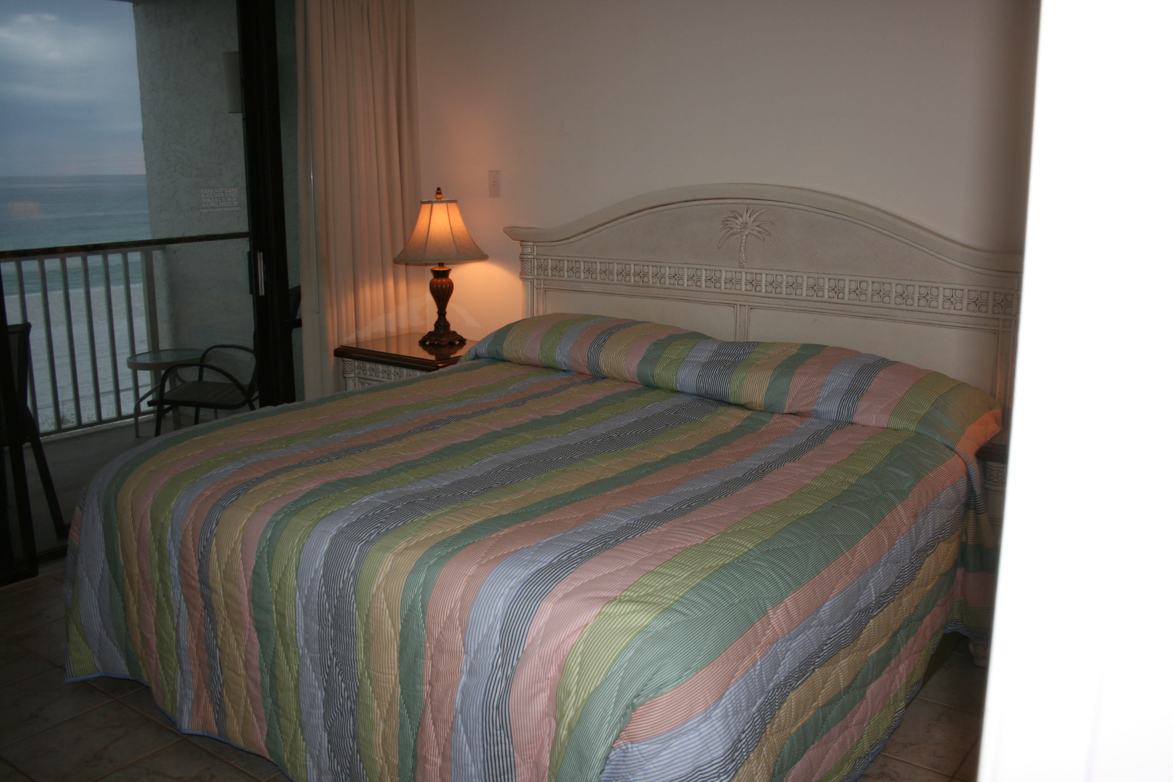 King bed in bedroom w/ patio door onto balcony