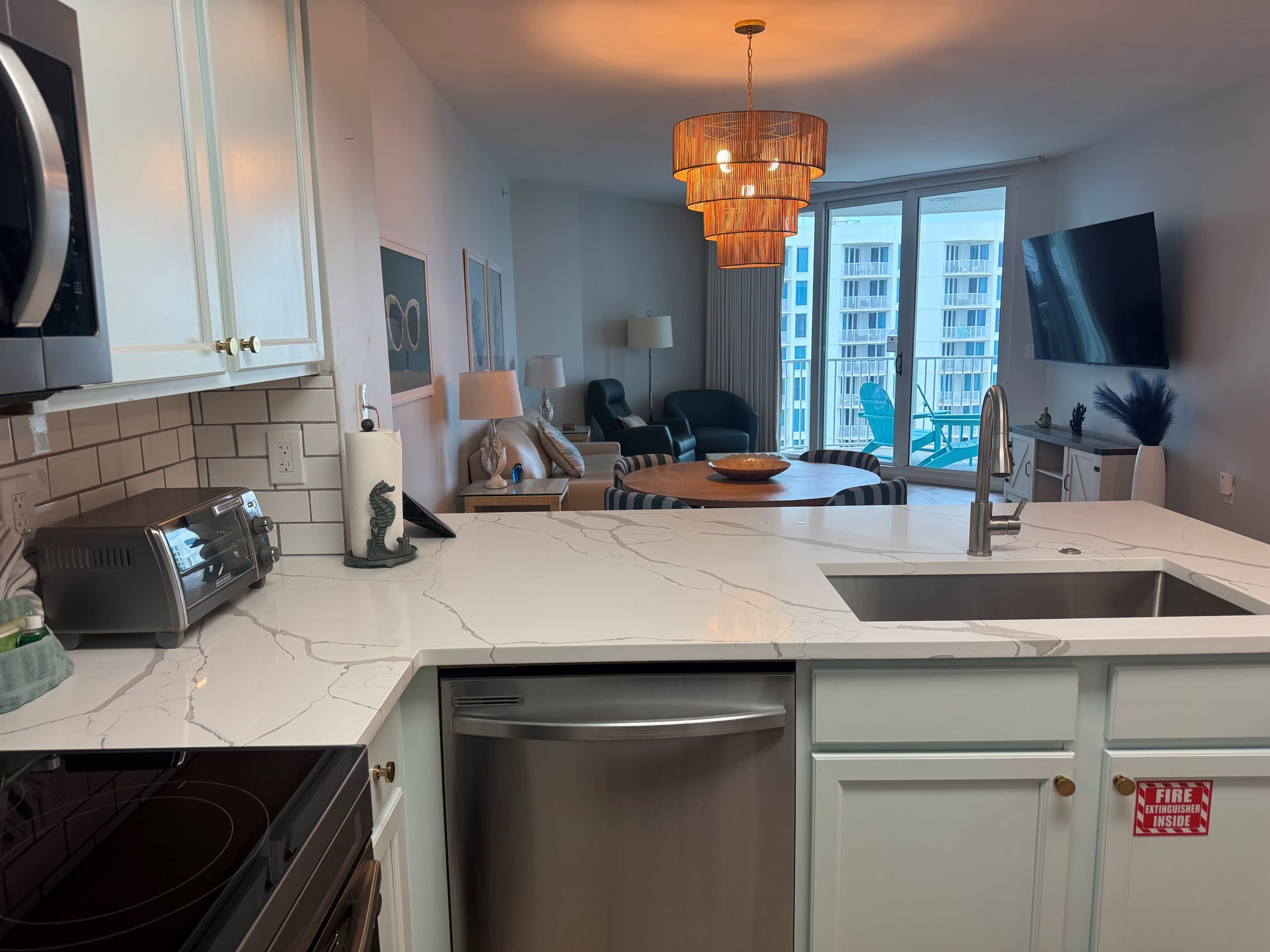 Looking out from the kitchen into the wide open floor plan and family room. Check out that 75 inch TV!