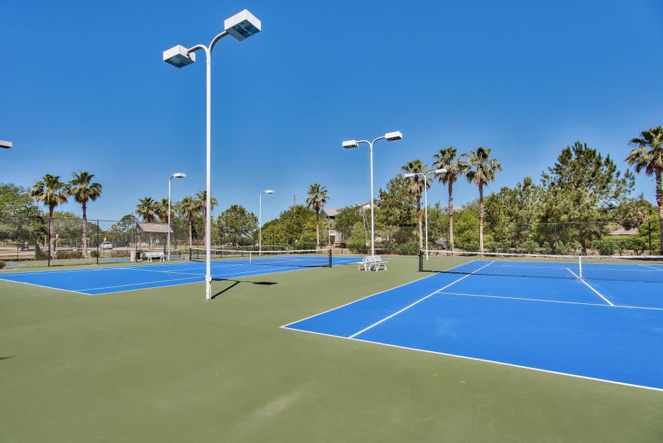 Lighted tennis courts ready for daytime matches or evening play.