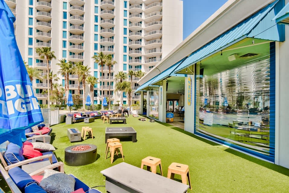 Lively outdoor hangout area w/ seating, games, and an open lawn atmosphere.