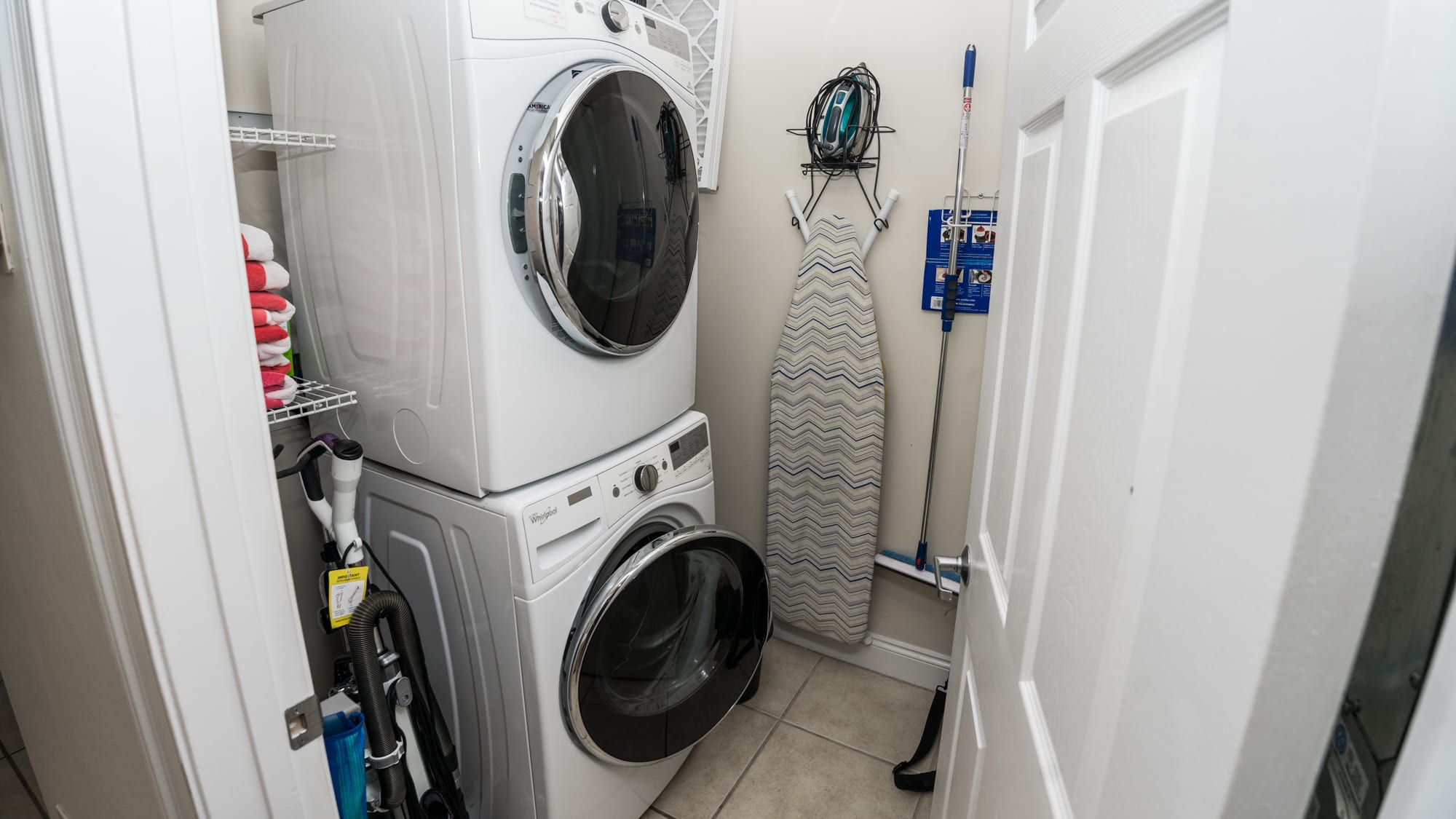 A Full-Size Stack Washer & Dryer in The Laundry Room,  located in the enterance hall.  