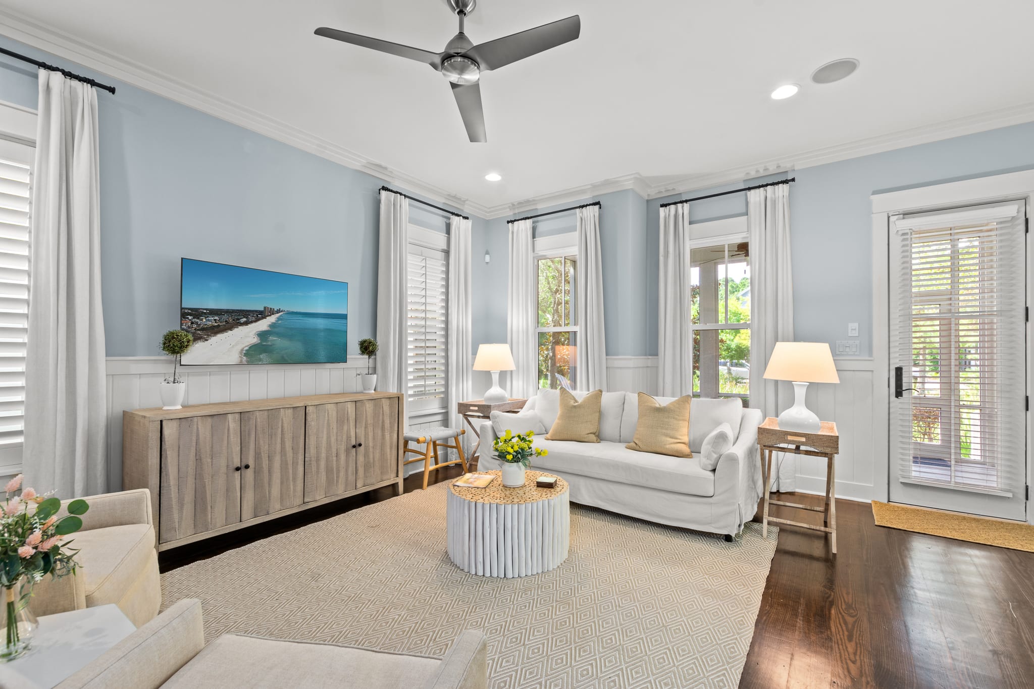 Bright living room w/ soft blue walls, comfy seating & large windows that fill the space w/ natural light. Bright living room w/ soft blue walls, comfy seating & large windows that fill the space w/ natural light.