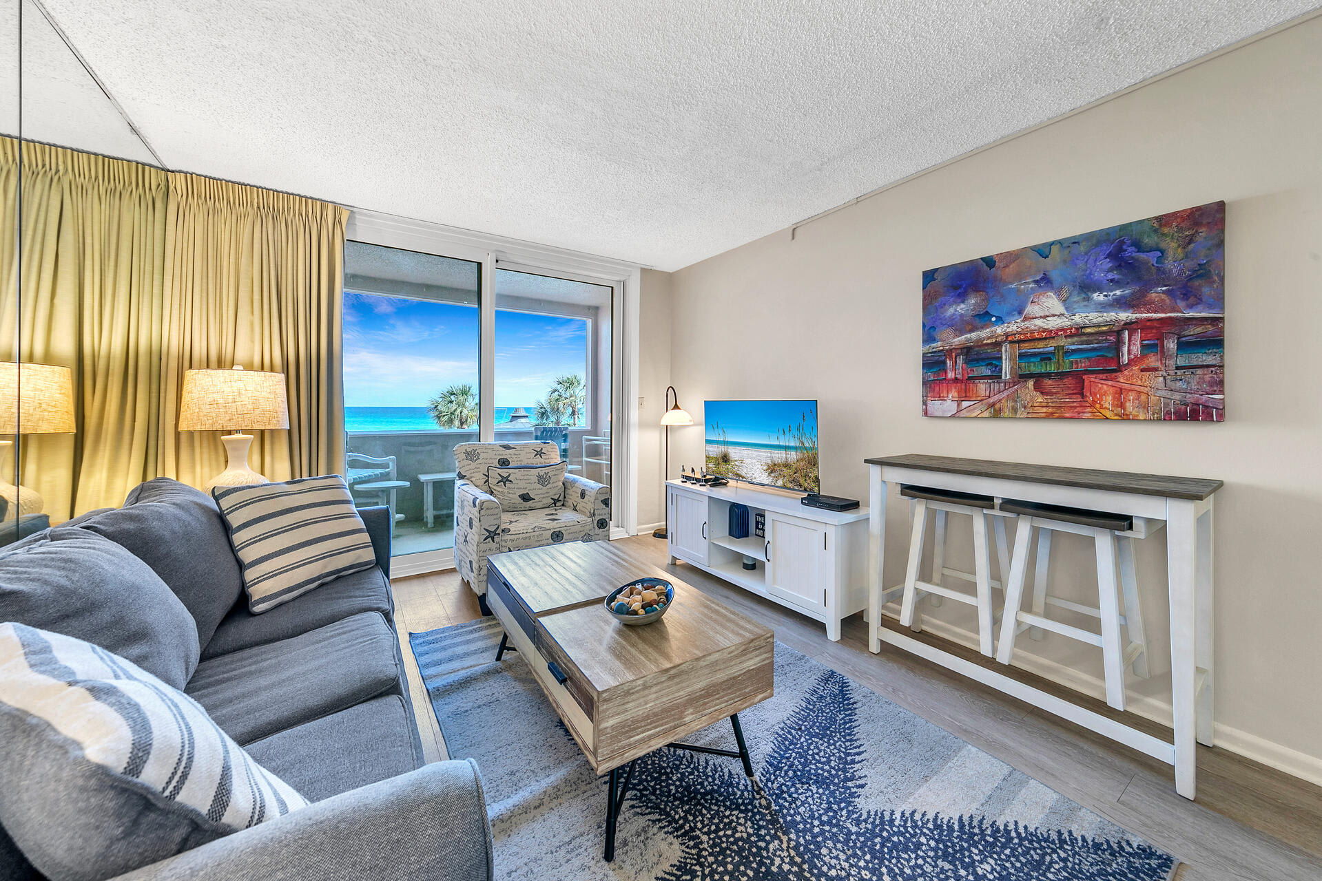 Relaxing living area w/ beach-inspired decor and direct access to the balcony views.