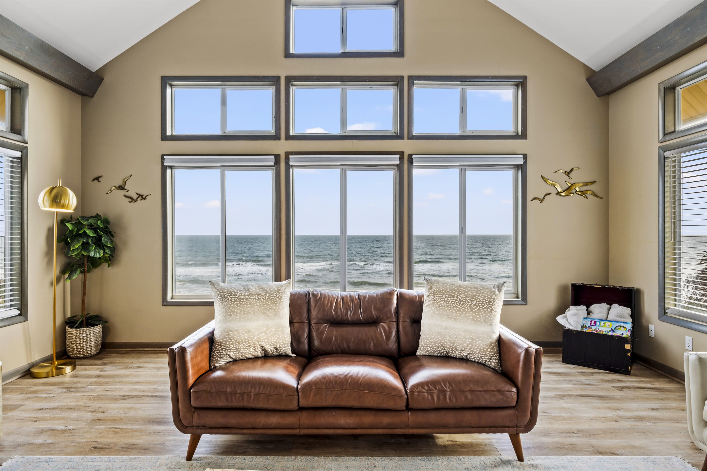 Experience coastal elegance in this room featuring a perfect blend of interior decor, soft textures, warm color tones, and comfortable furnishings, all while enjoying the magnificent ocean vie
