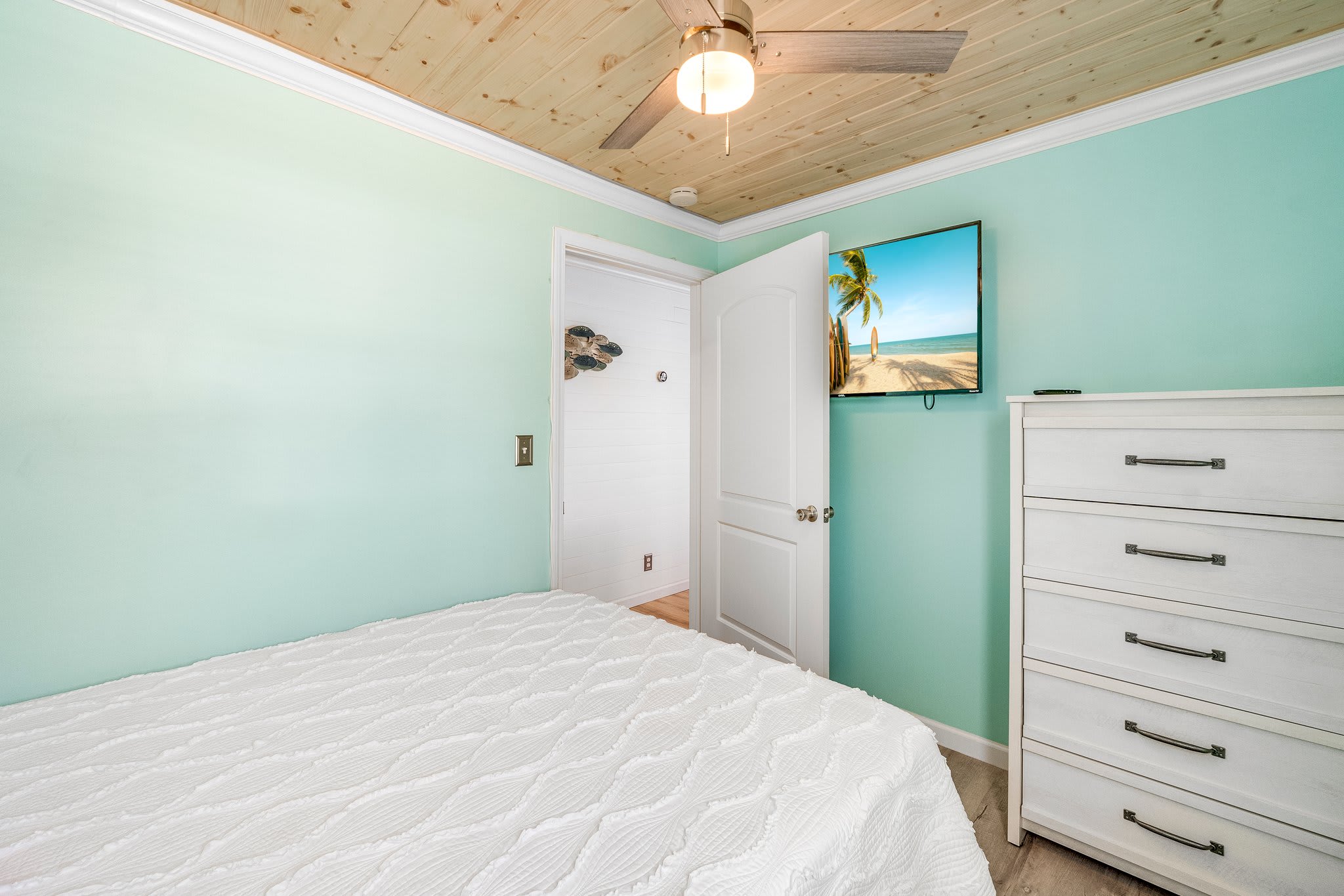 Bedroom upstairs with a queen bed and 50 inch Roku tv.