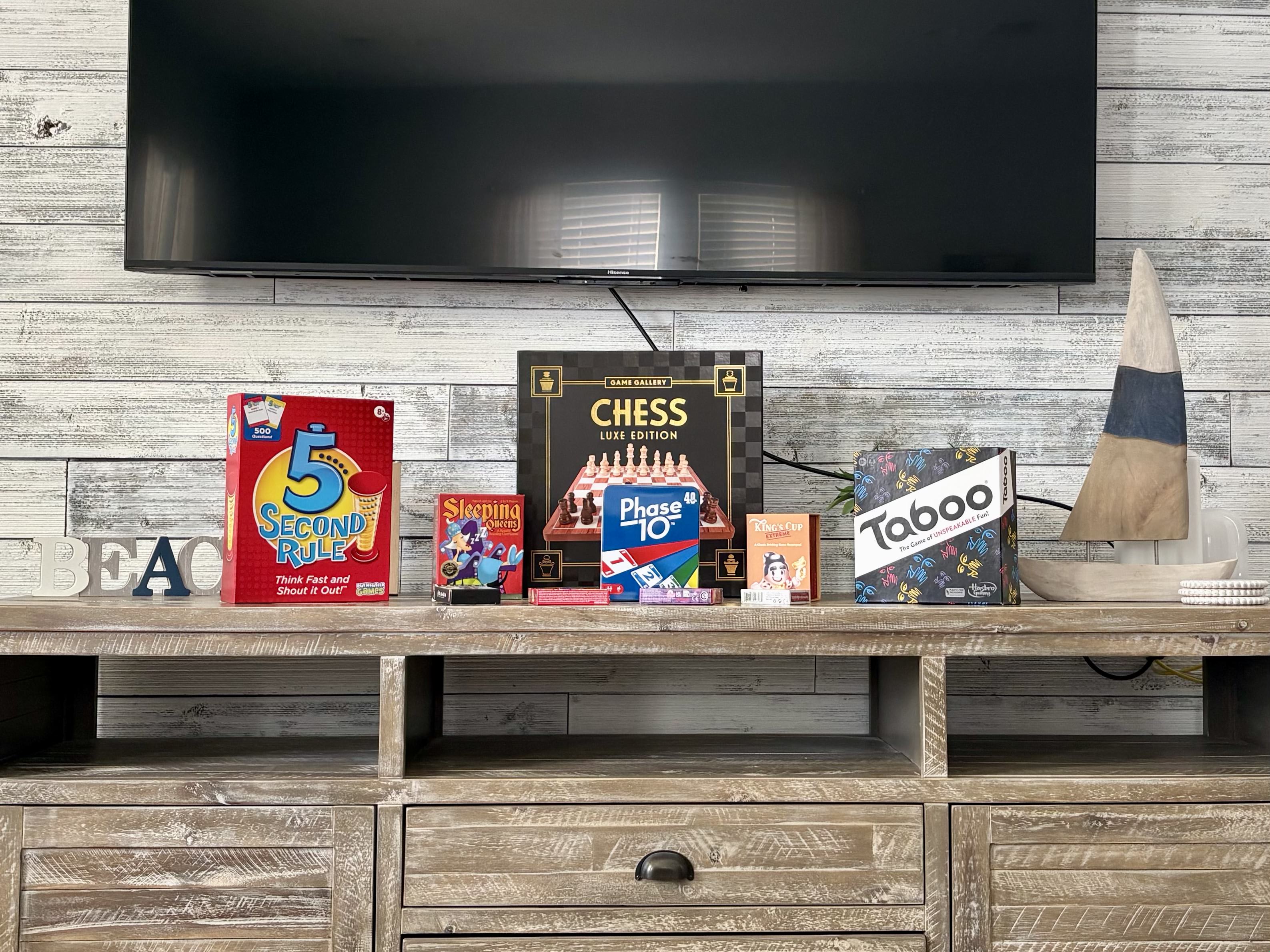 Entertainment console with TV and a selection of board games for guest enjoyment.