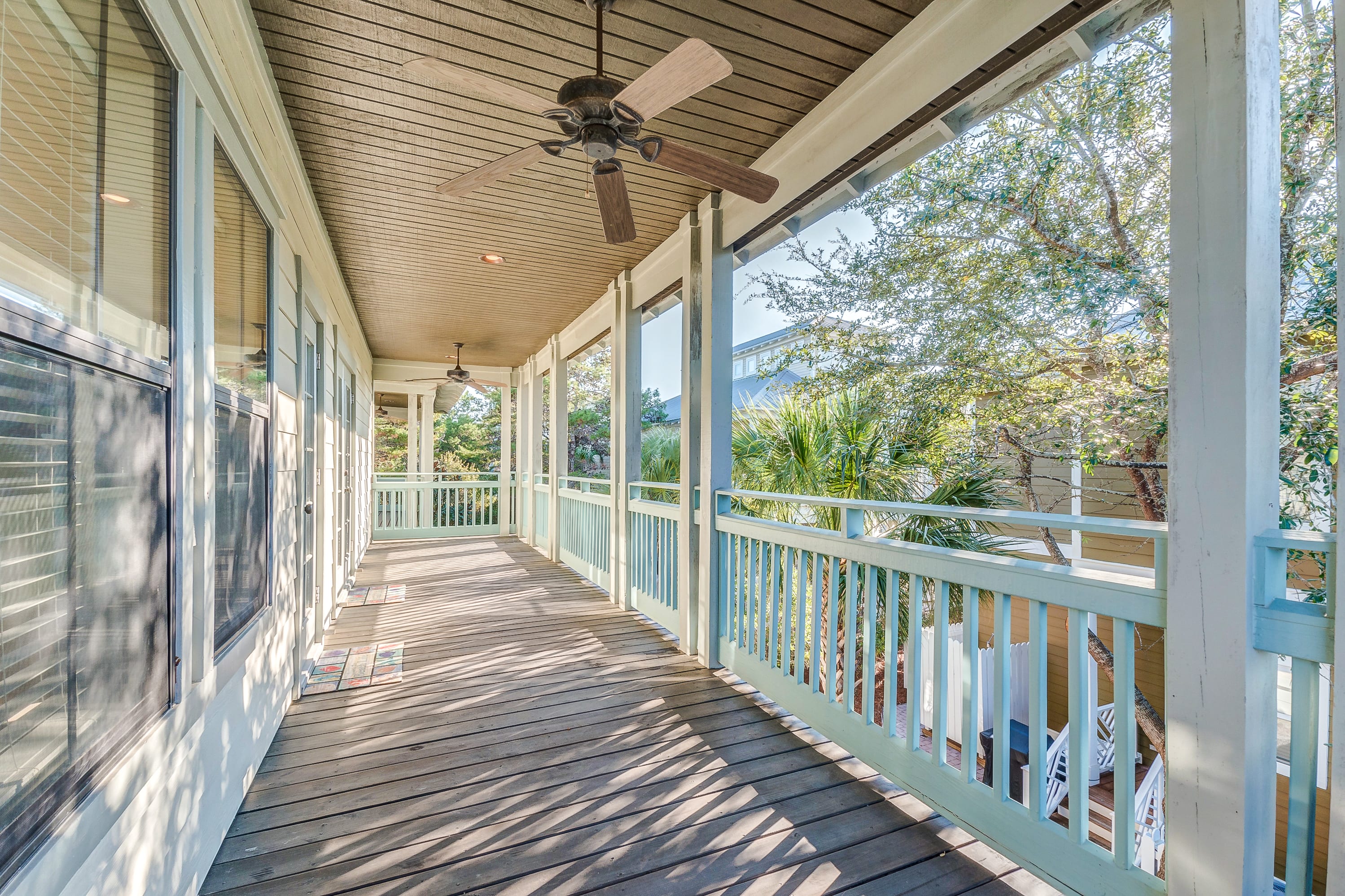 Second floor covered porch with ceiling fans and adirondack chairs