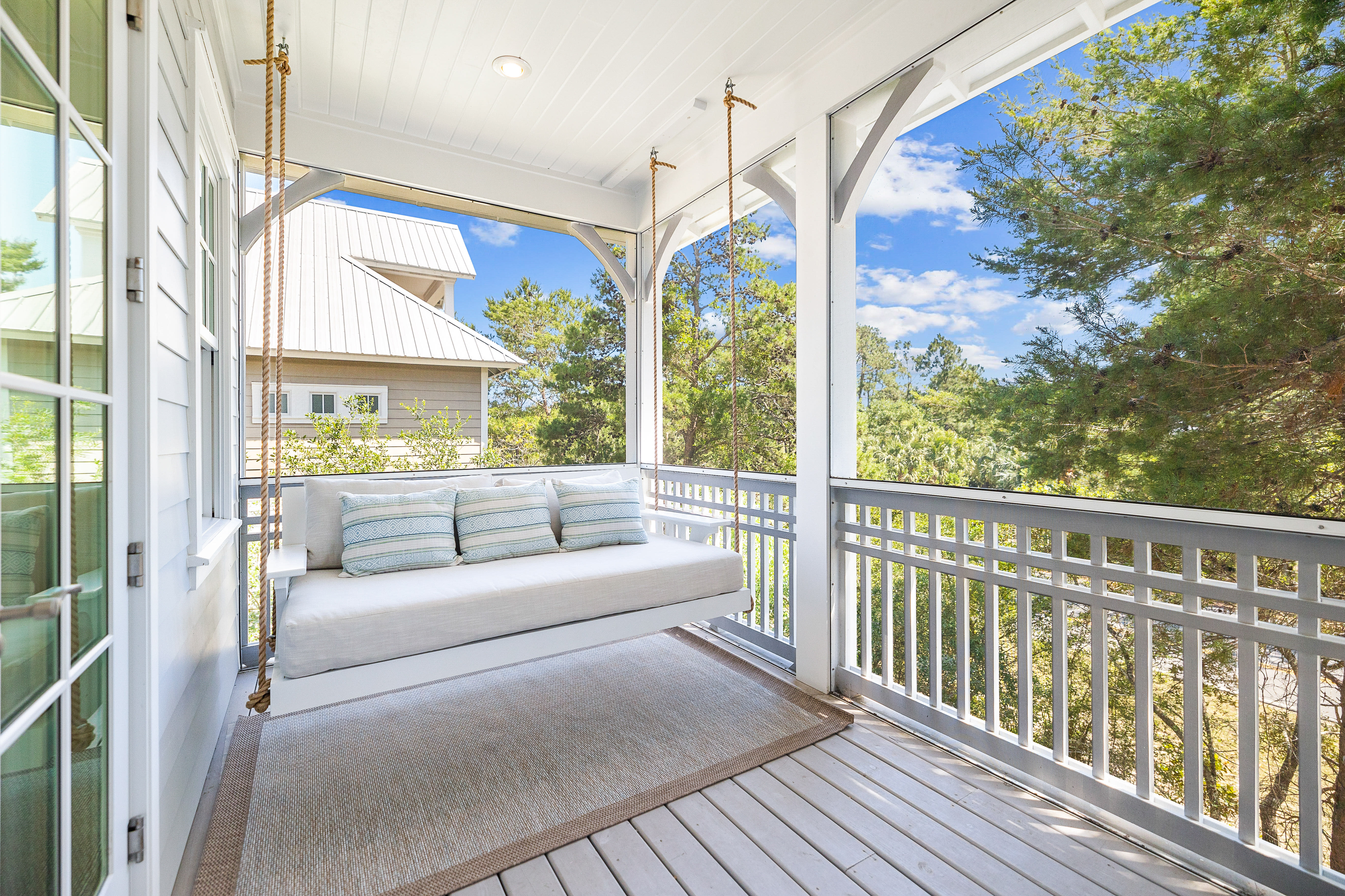 Master bedroom private balcony screened in with bed swing and couch