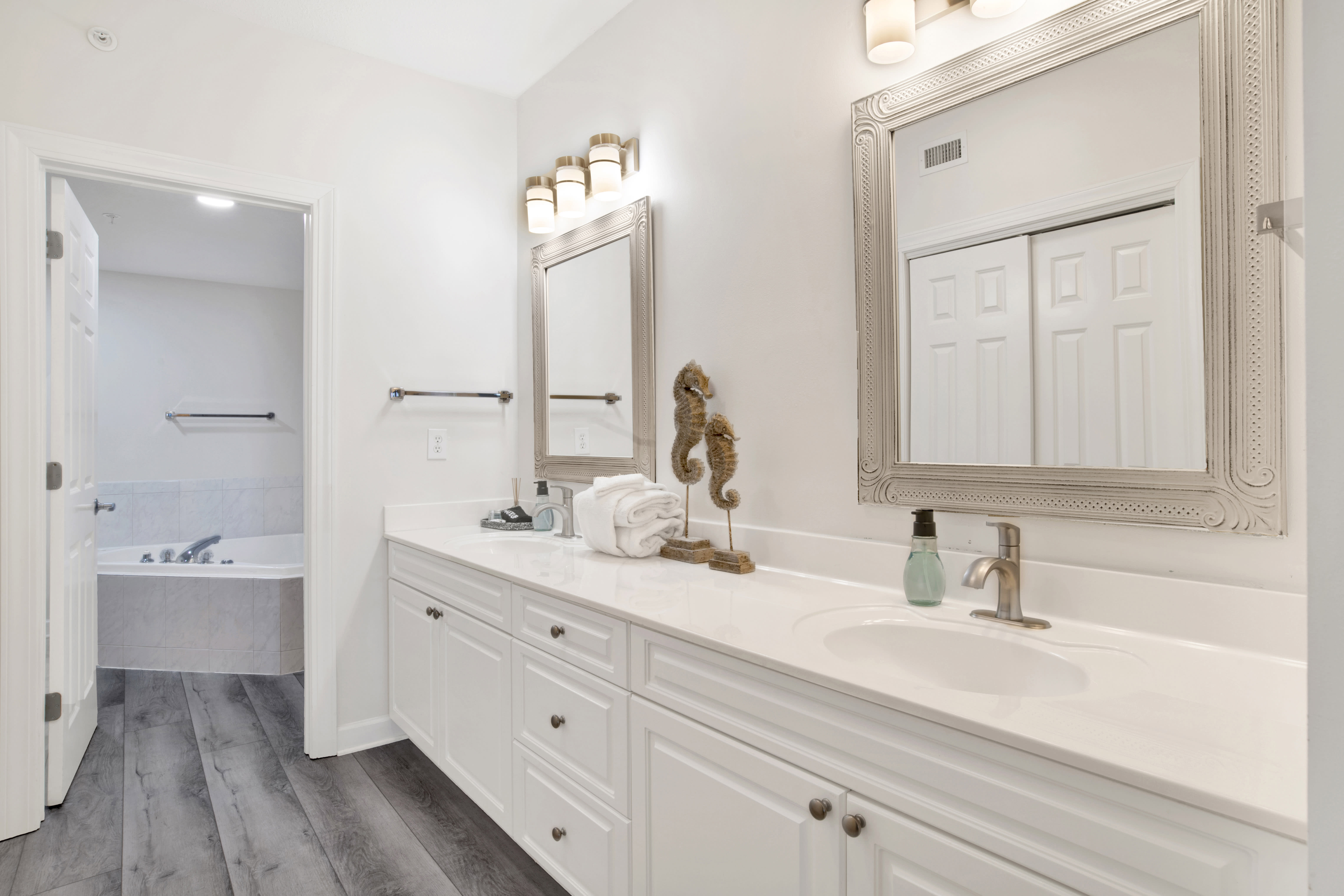 Dressing area with double sink, large walk-in closet, and bathroom with jetted tub and shower