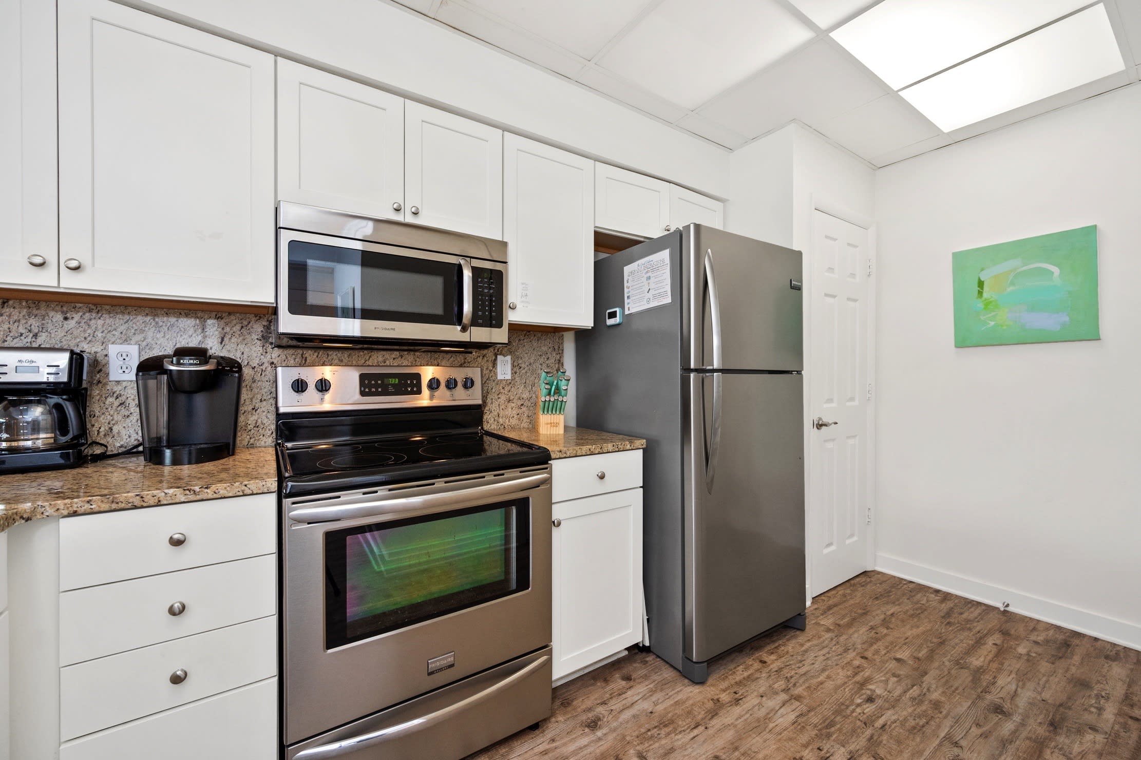 Fully stocked kitchen with stainless steel appliances.