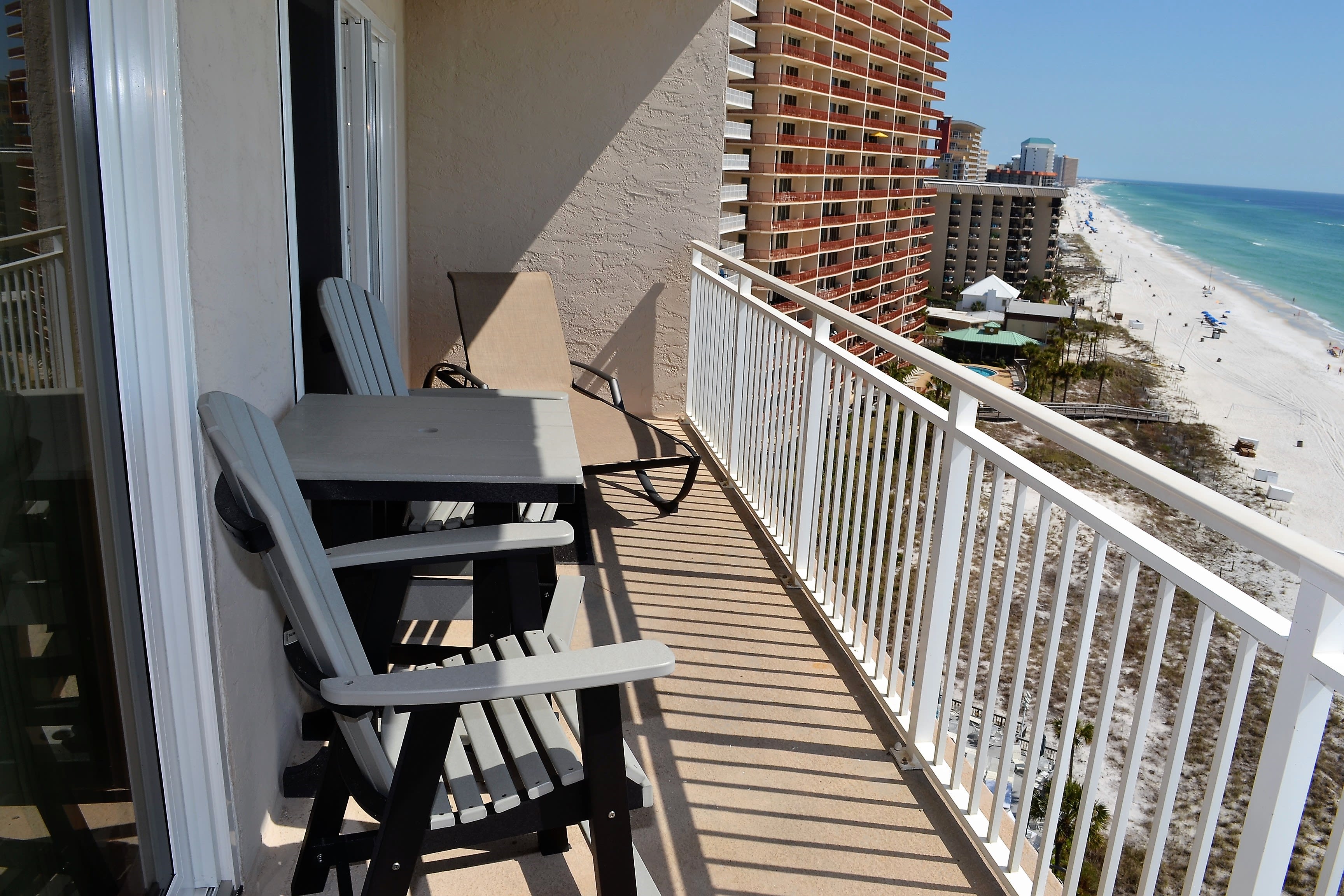 Balcony with 2 counter height chairs and a lounge chair
