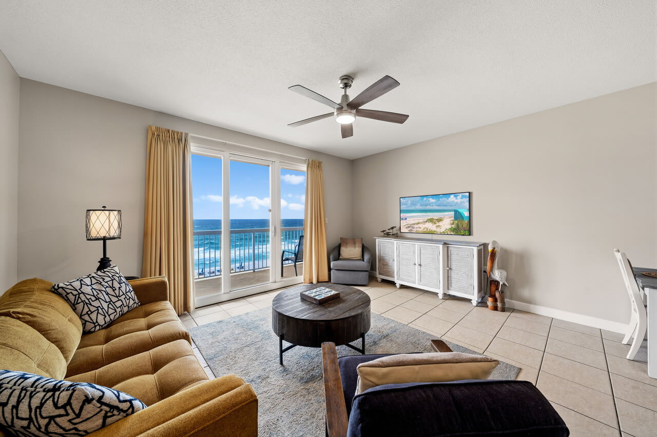 Bright Gulf-front living room with balcony access, coastal decor, and ocean views