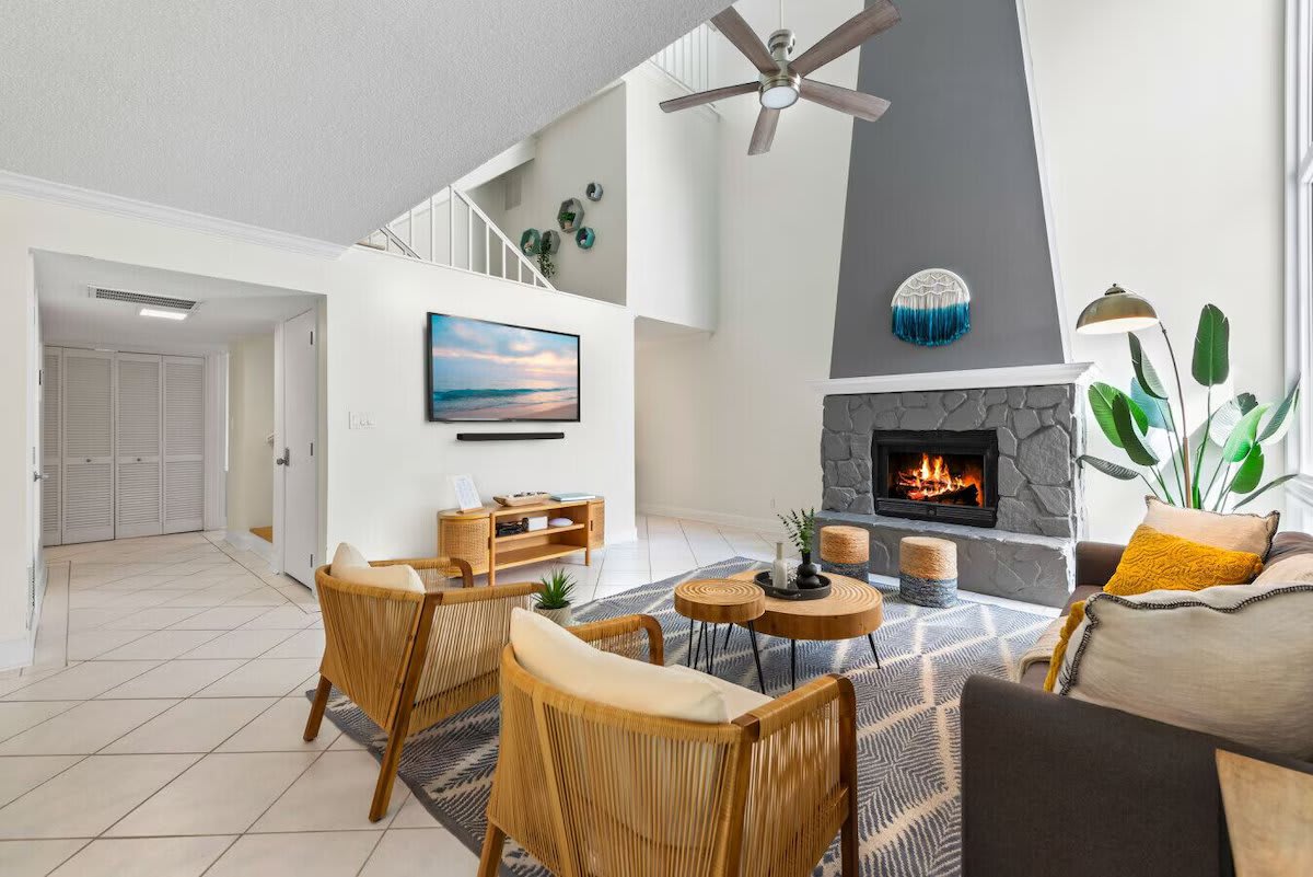 Cozy up at Seabreeze Villa ðŸ”¥ This inviting living room features a warm fireplace and coastal-inspired decor&mdash;perfect for relaxing after a day at the beach. Your seaside escape is just a booking away! ðŸŒ´âœ¨