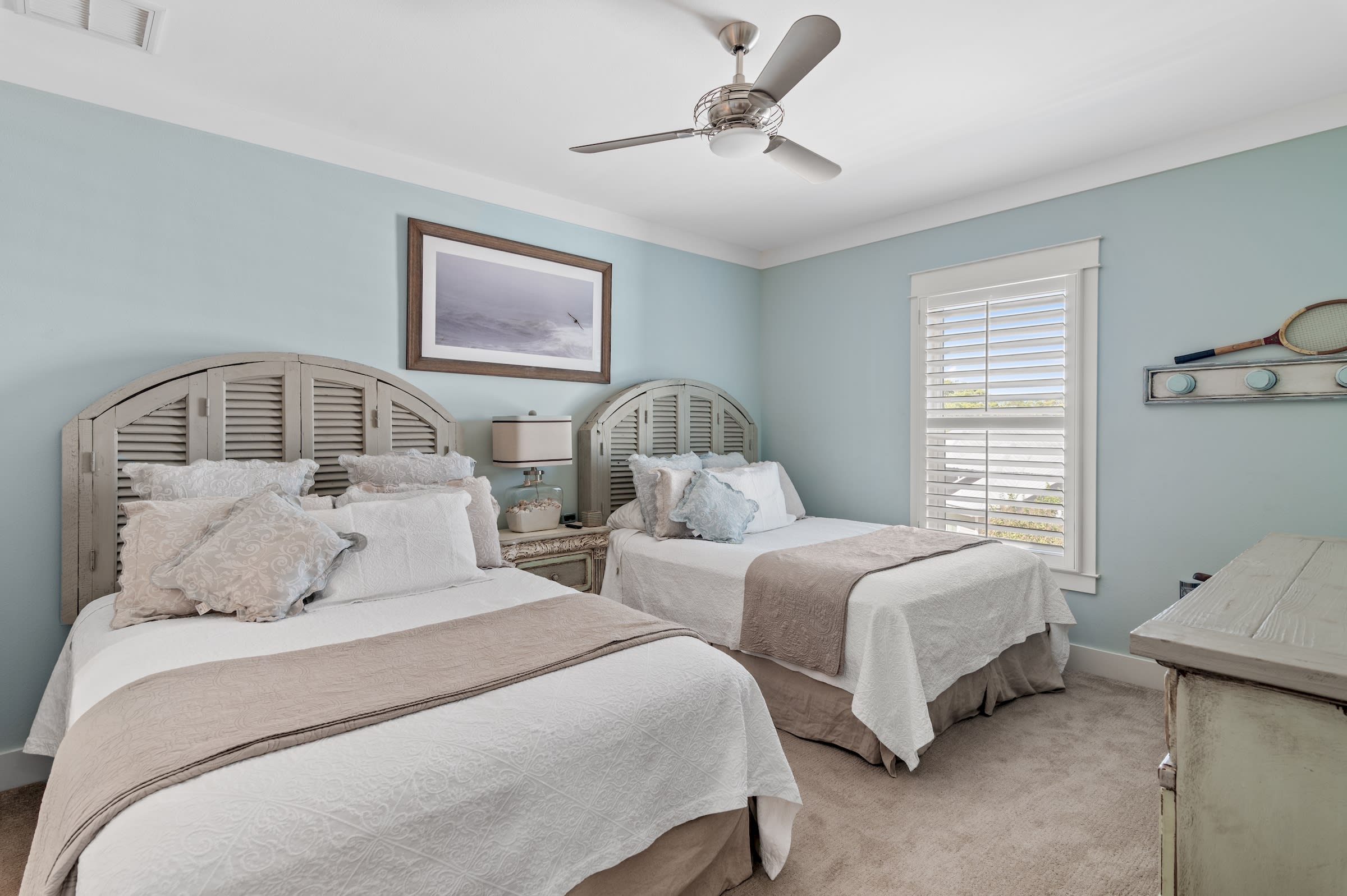 Bedroom two with two queen beds, adjoining make-up room with sink.