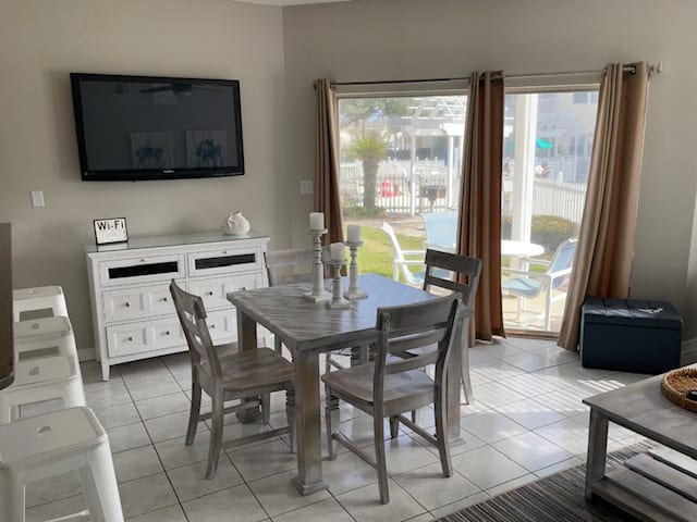Dining area opens to back patio that is steps from grill and pool