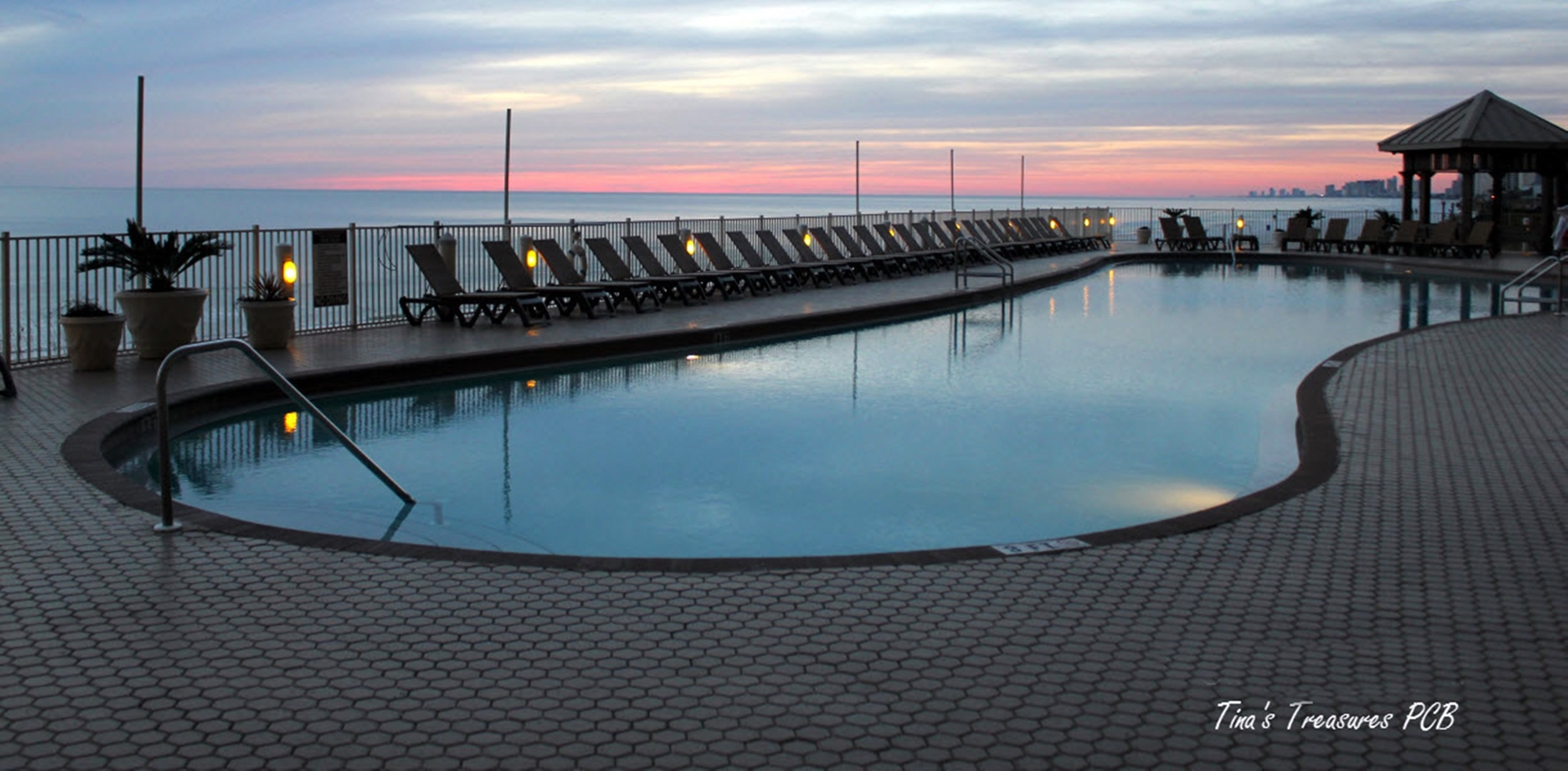 View of our tropical beach front 120 ft heated pool at sunset.