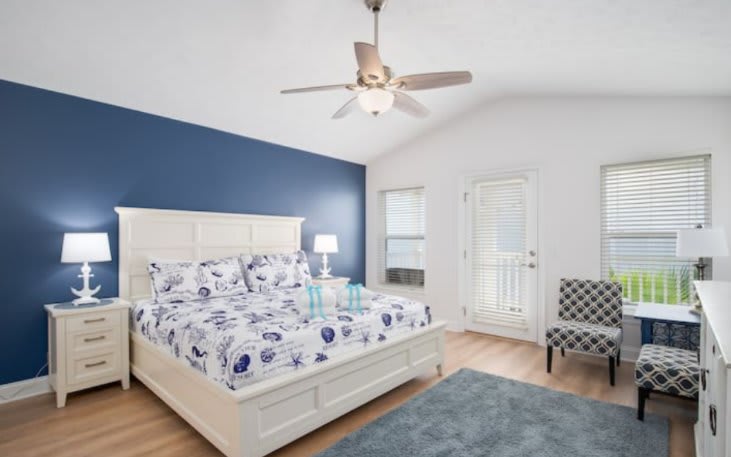 Master bedroom with king bed, sitting area, mini fridge, 40" smart tv, and private balcony.