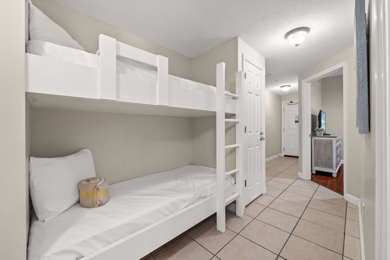Built-in hallway bunk beds with bright tile floors and coastal style