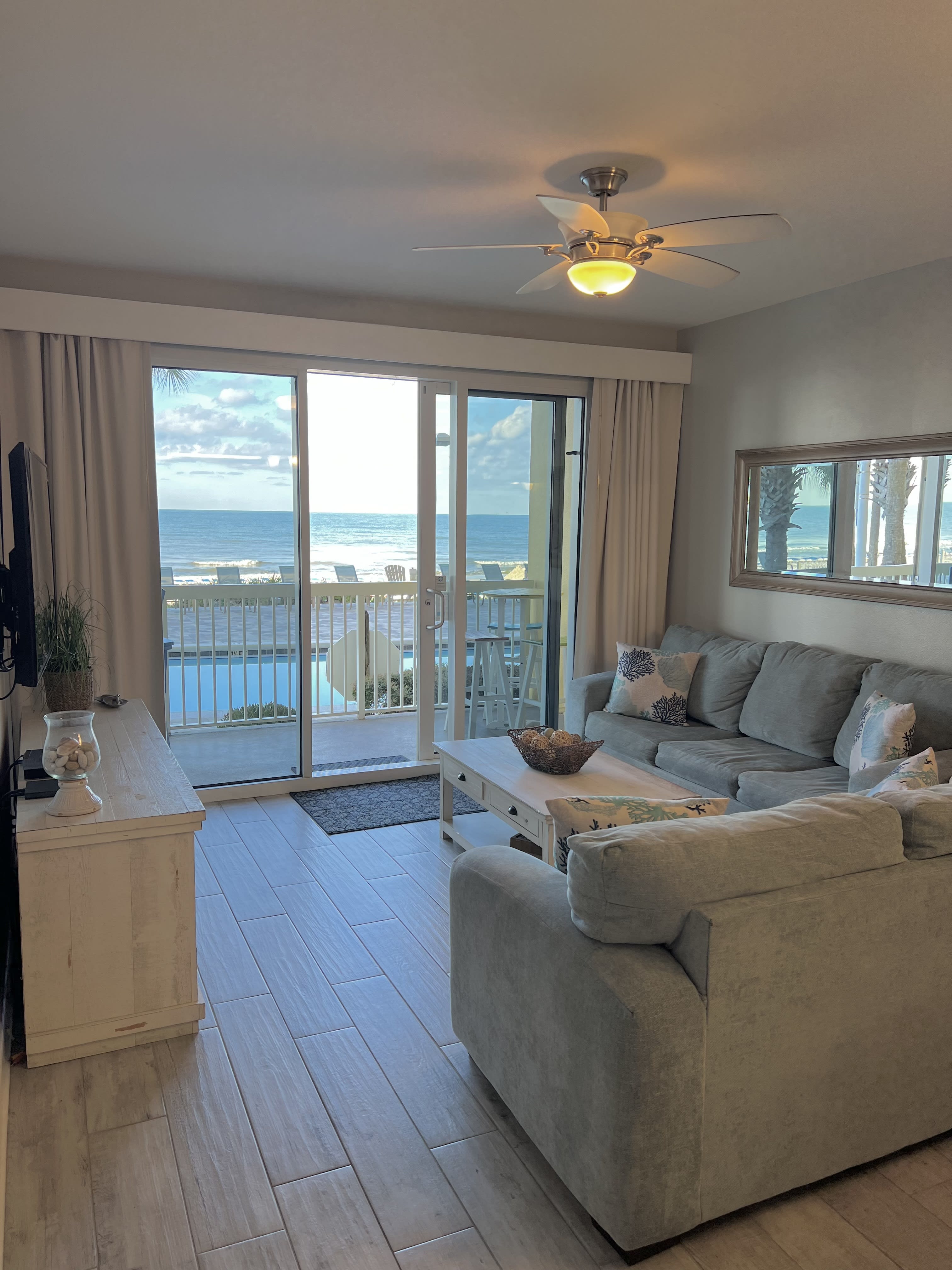 A beautifully updated living room with views of the Gulf with endless shades of blue stretching to the horizon.