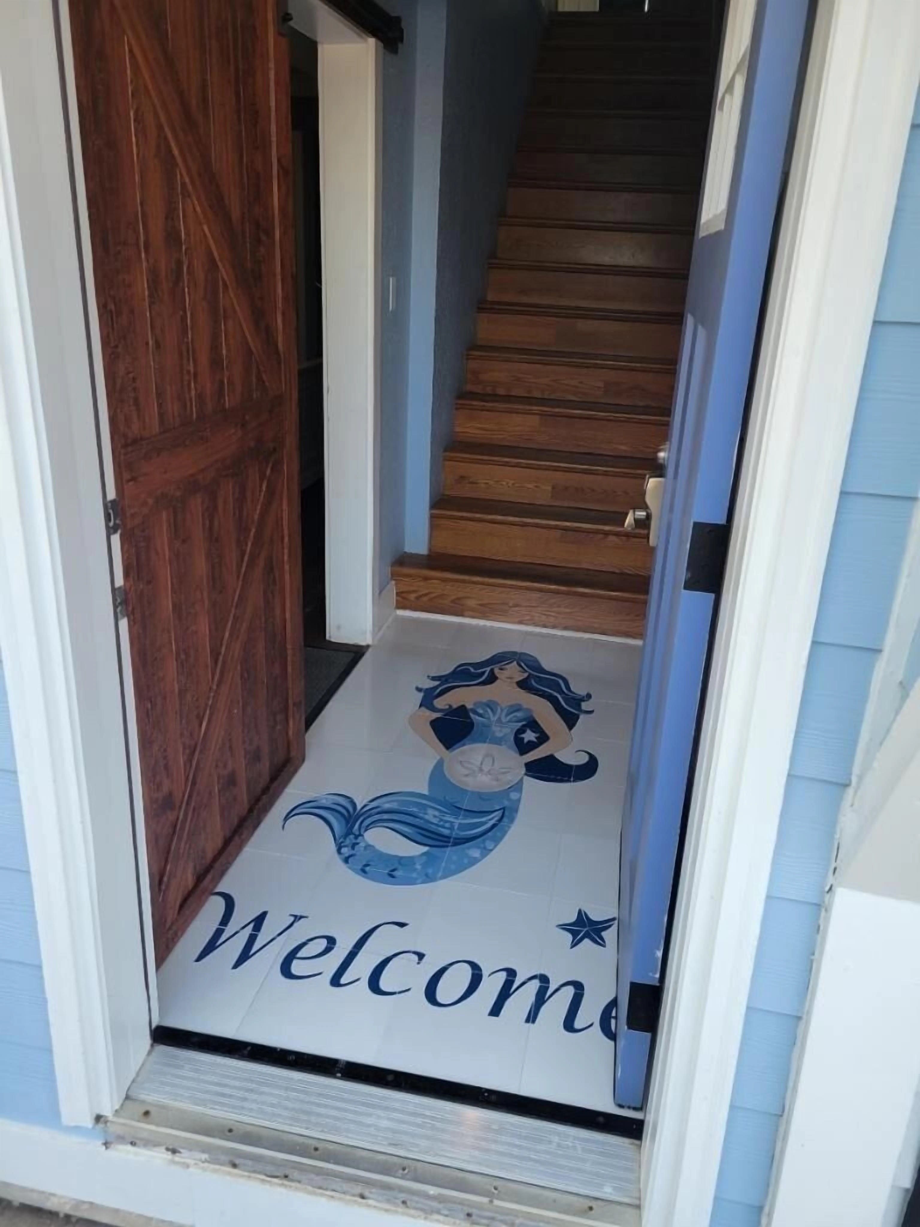 Entry stairs to living area with barn door to ground level bedrooms