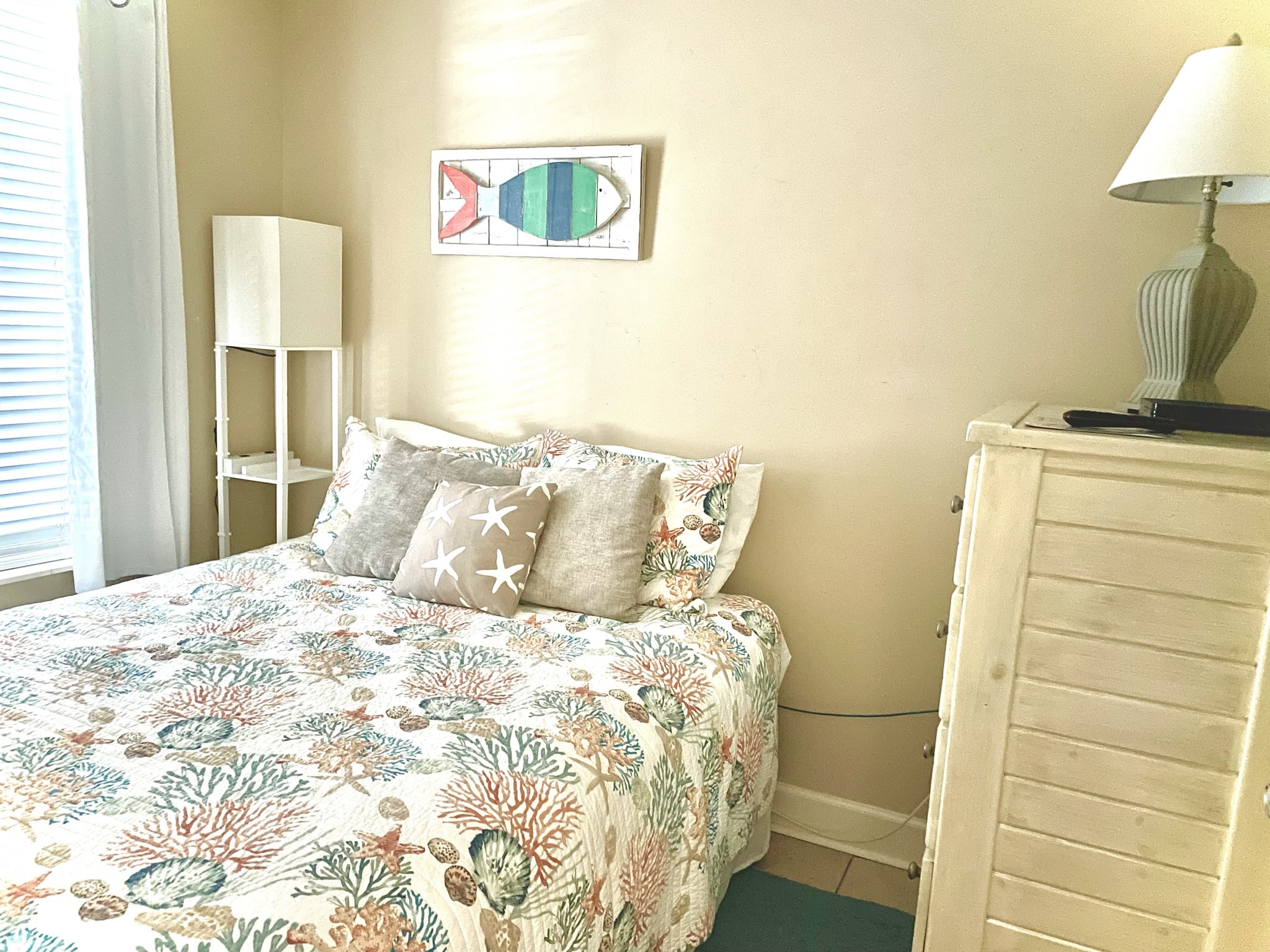 Queen bedroom with tall dresser and 32 inch TV