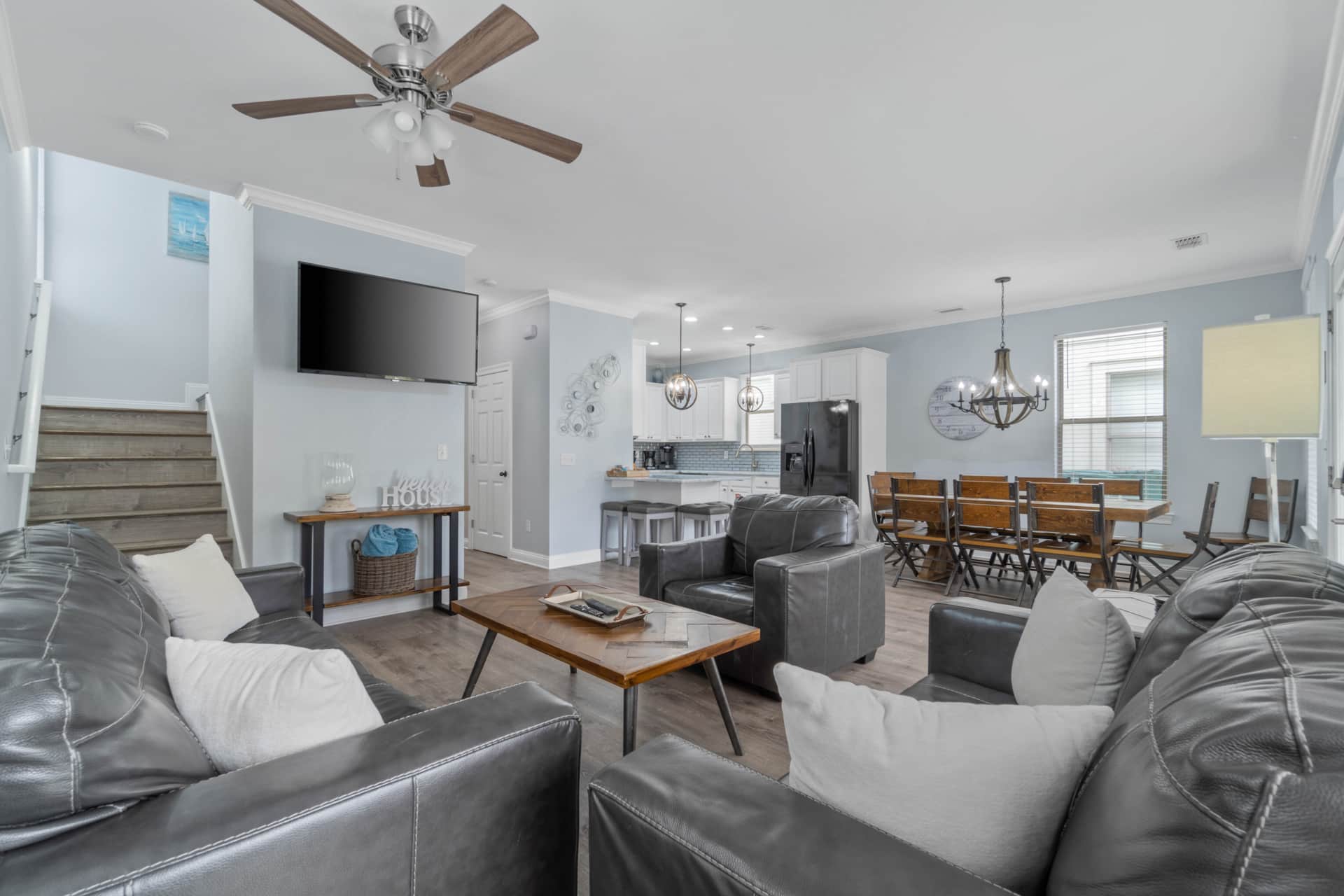 Large living room with TV; dining room and kitchen in background