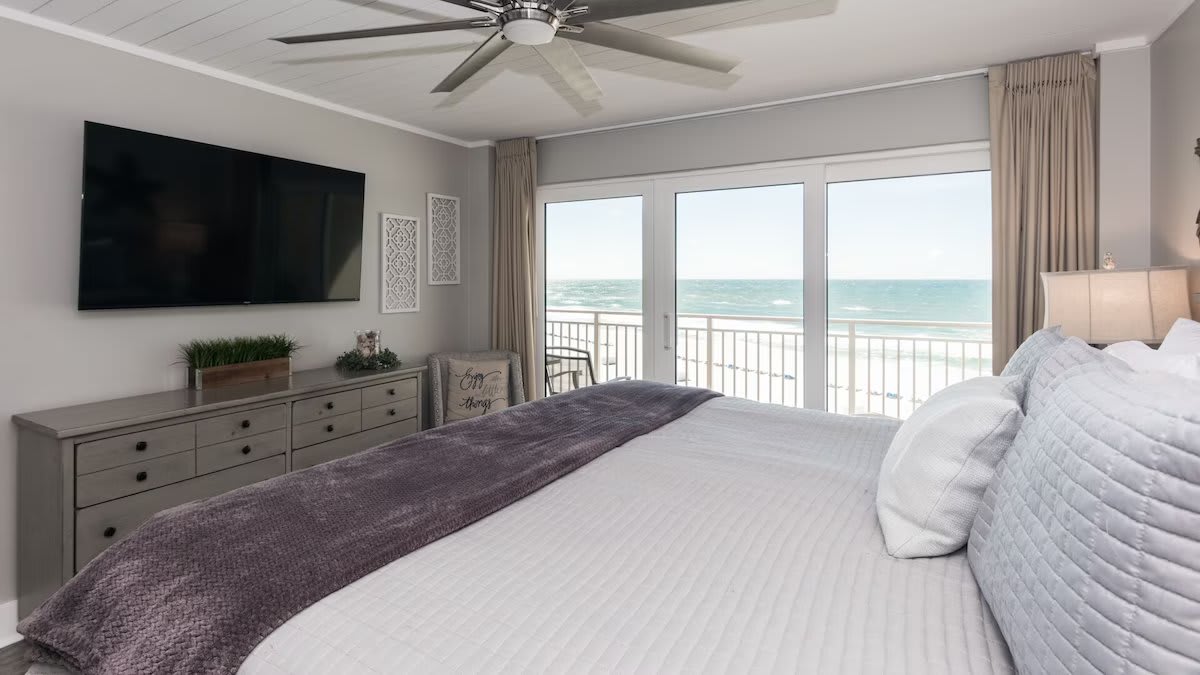 Roomy master bedroom with balcony access and 60" smart tv.