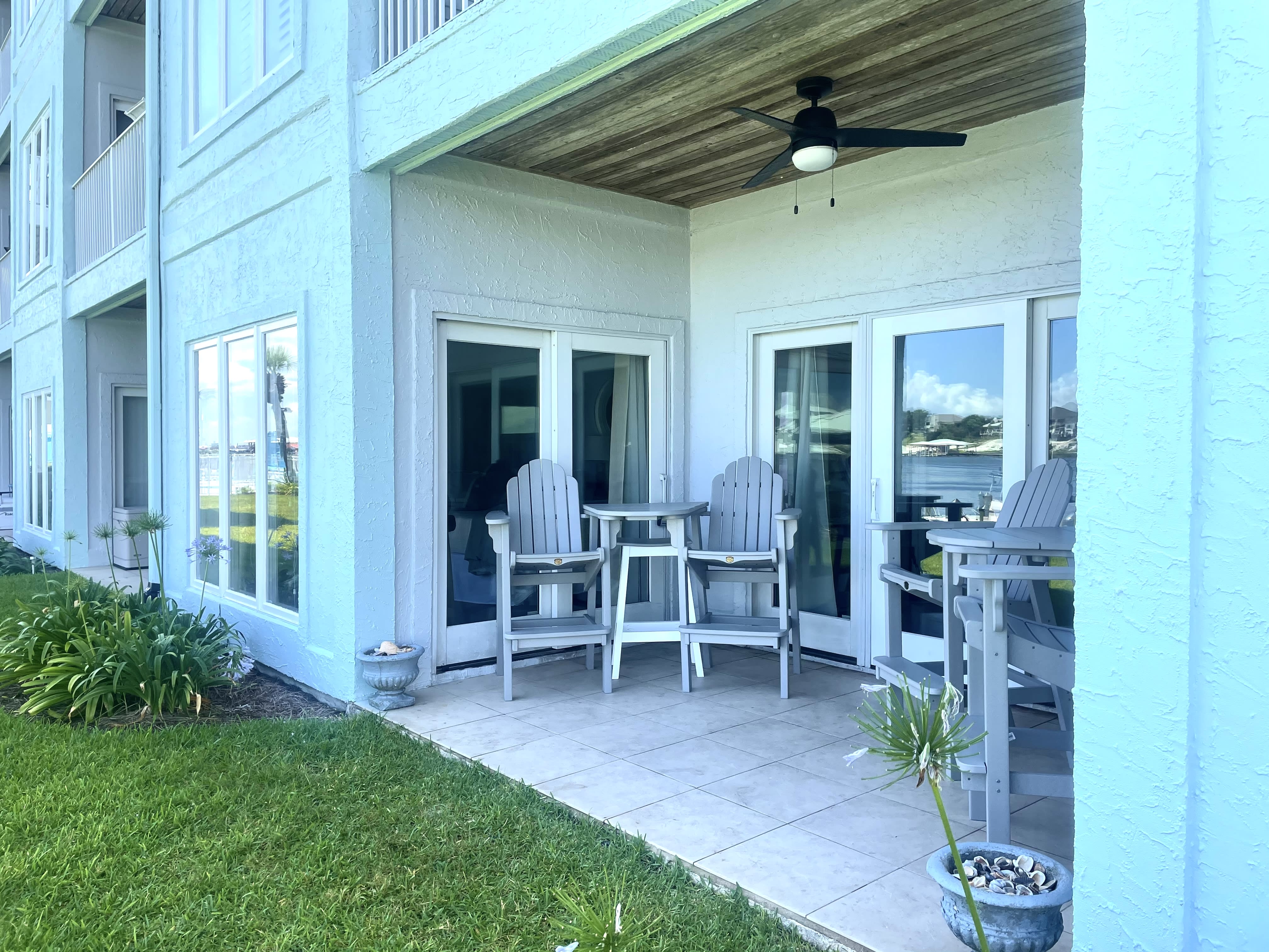 PATIO WITH TWO BAR HEIGHT CHAIRS &amp; TABLE SETS AND ONE STOOL BEHIND EACH TABLE 