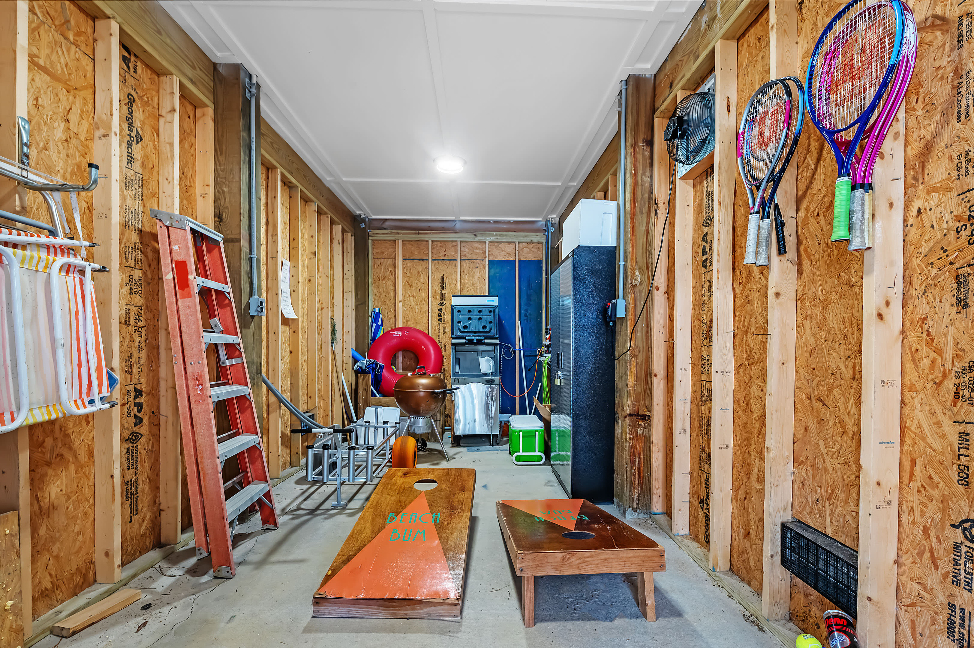 Storage room with beach wagon and commercial ice machine. Also cornhole game