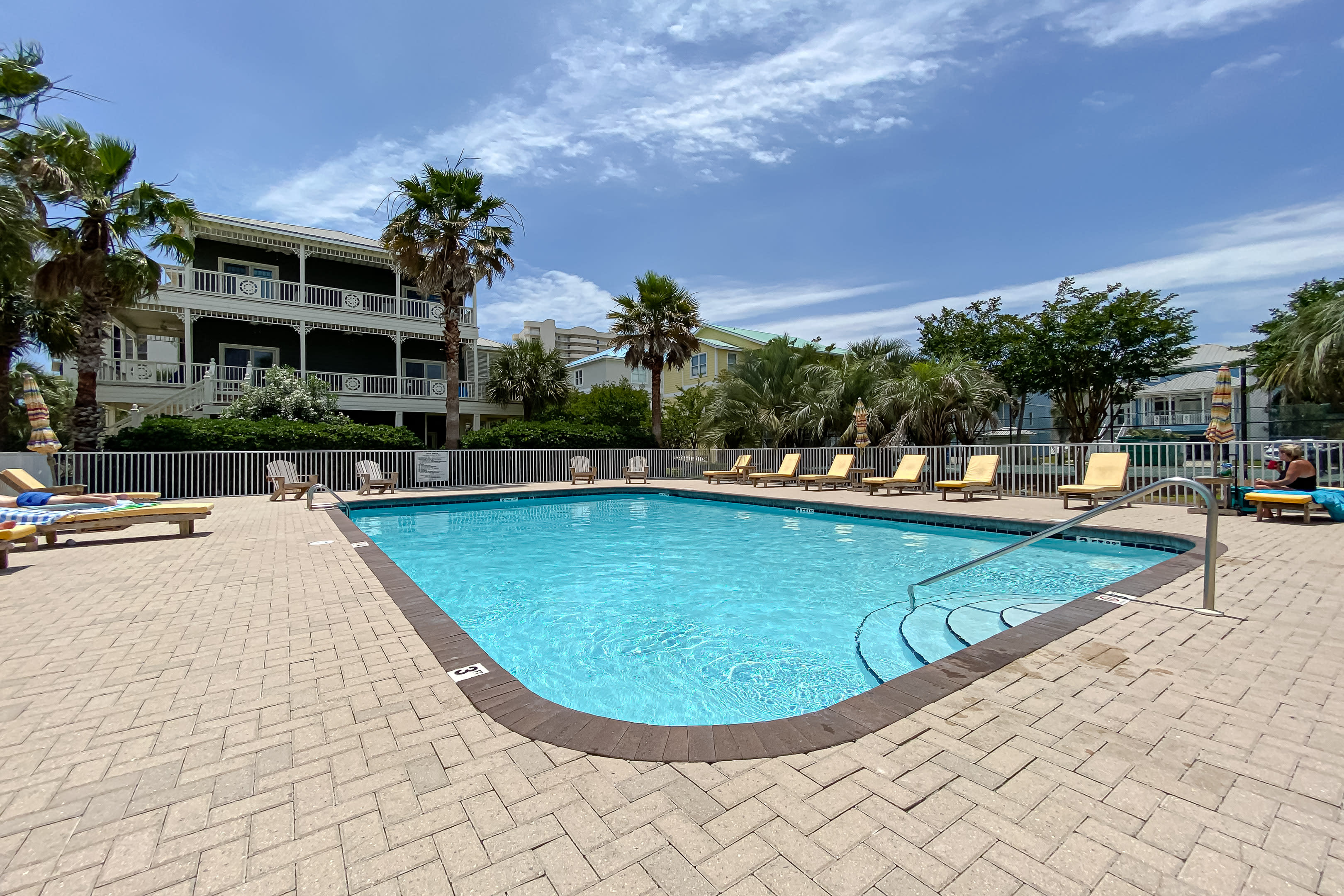 Large Community Pool with Lounge chairs and umbrellas.
