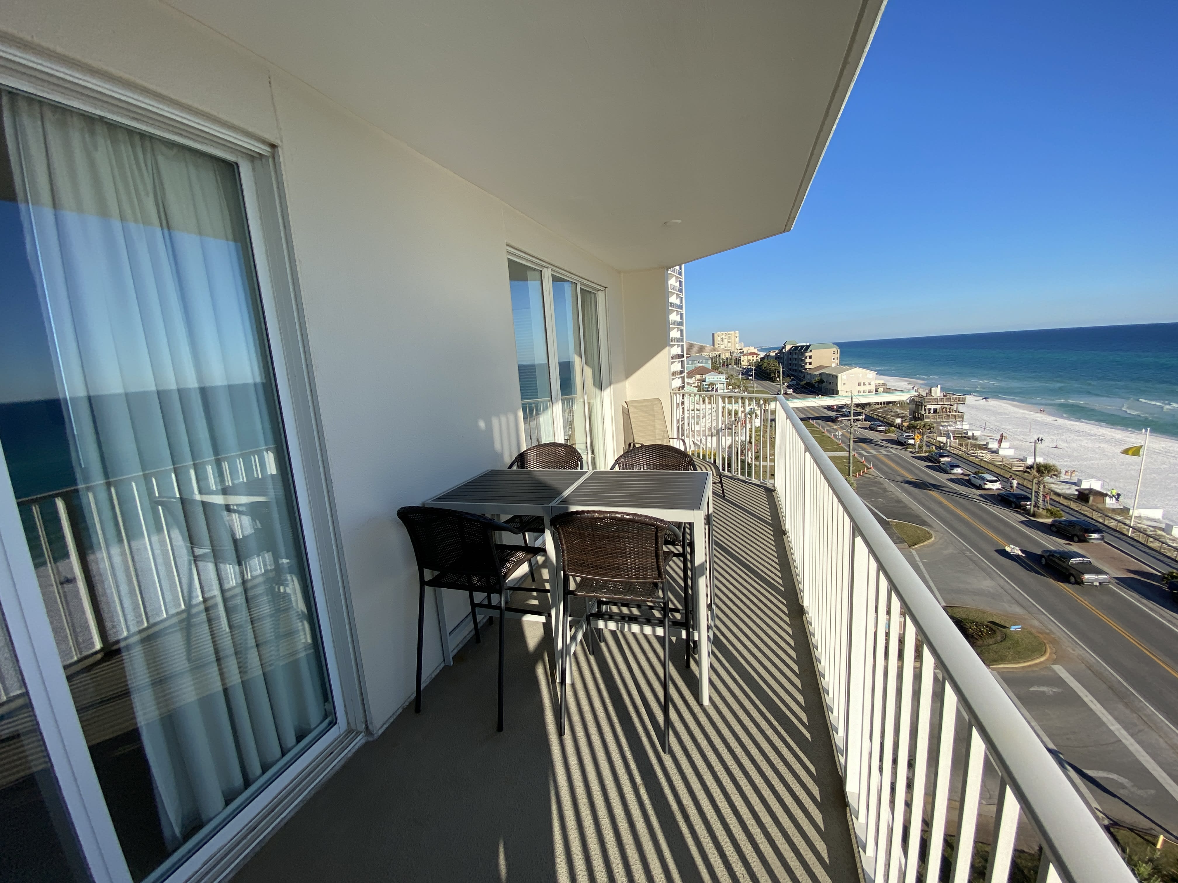 Gulf view balcony with table seating for 4 guests and a chaise lounge.