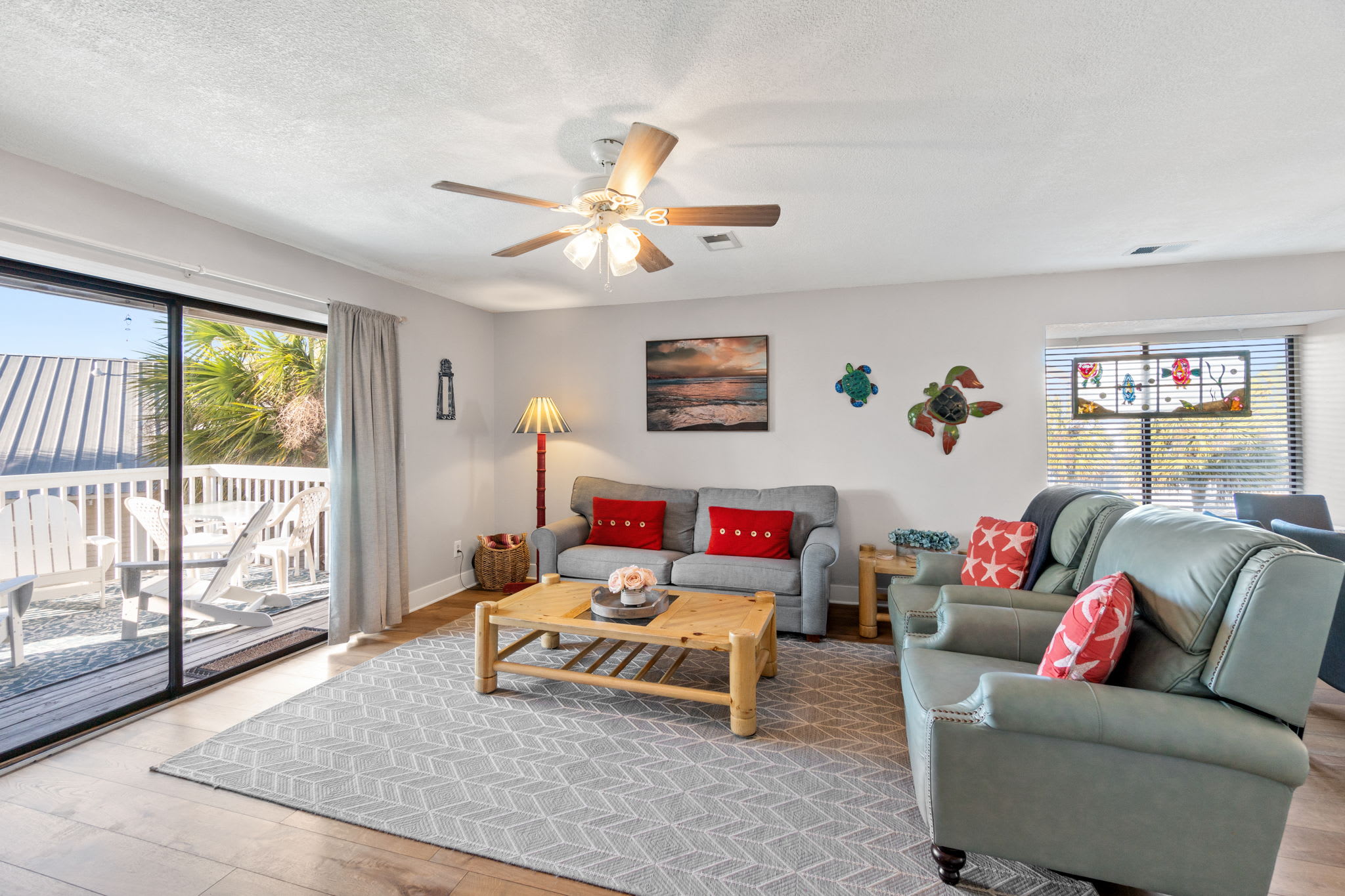 Living room with queen sleeper sofa and leather recliners. Smart TV on wall. 