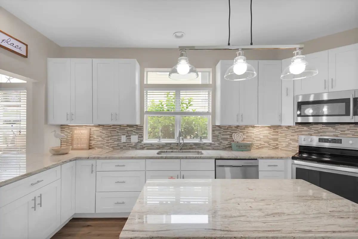 Sunkissed-13 kitchen features granite counters, stainless appliances and farm sink.