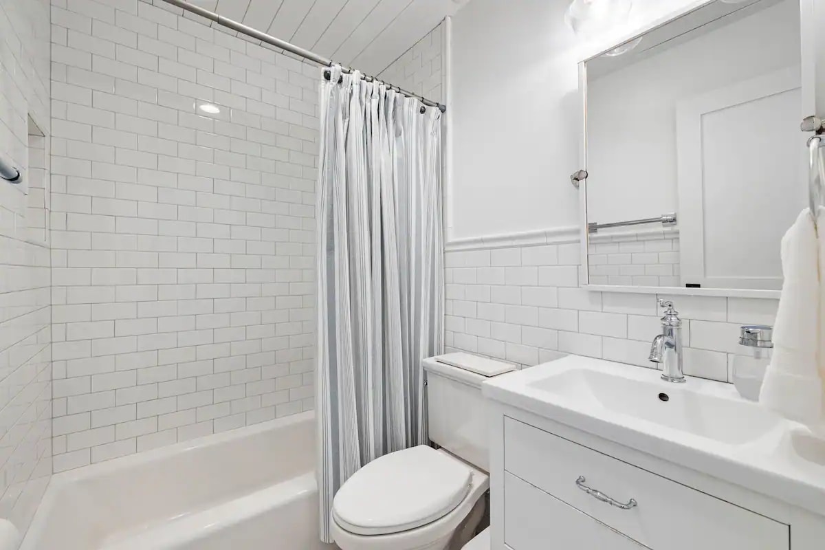 Full bath with white subway tile and marble floor 