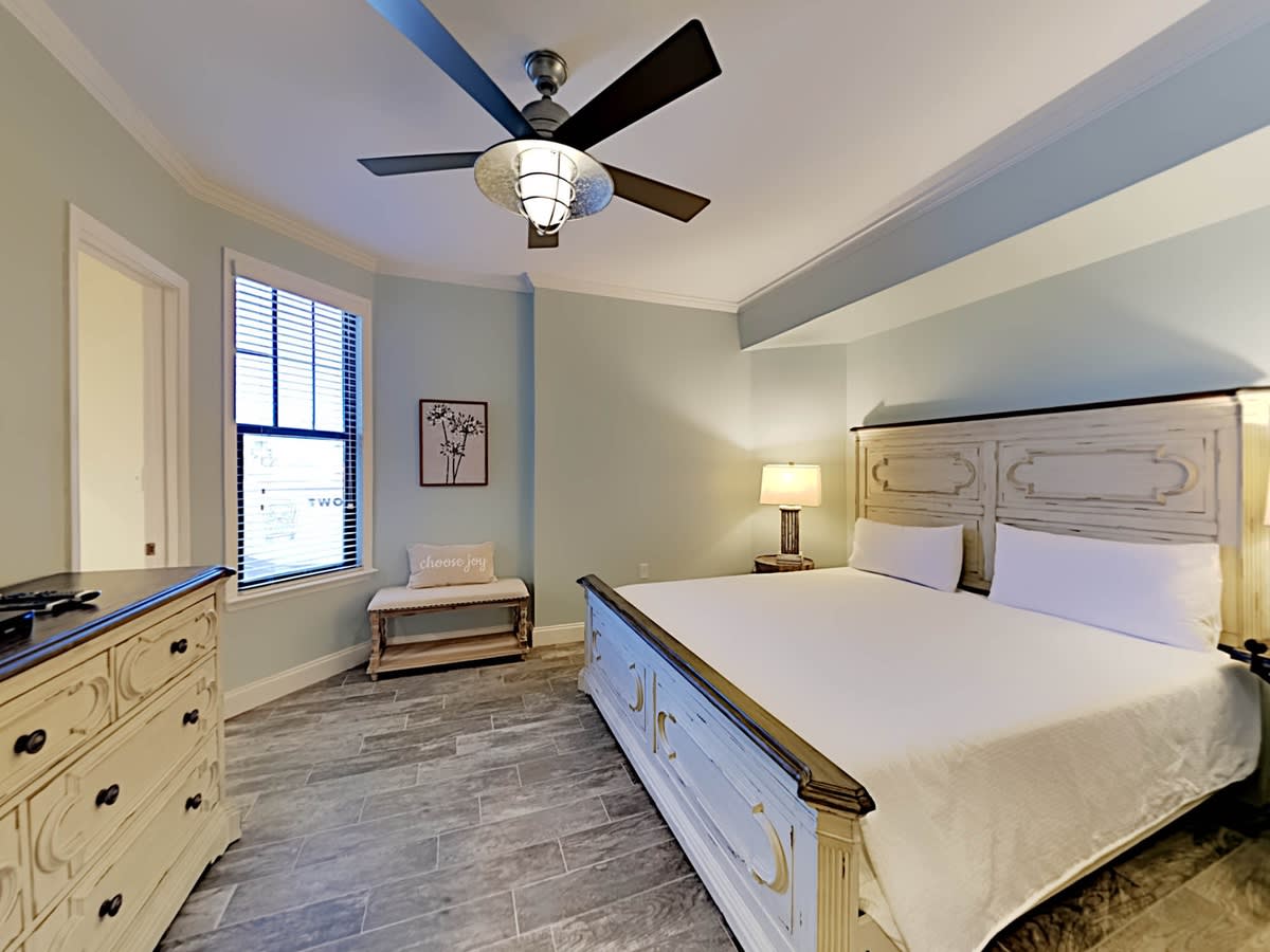 Second king bedroom features flat screen, ceiling fan attached private bathroom.