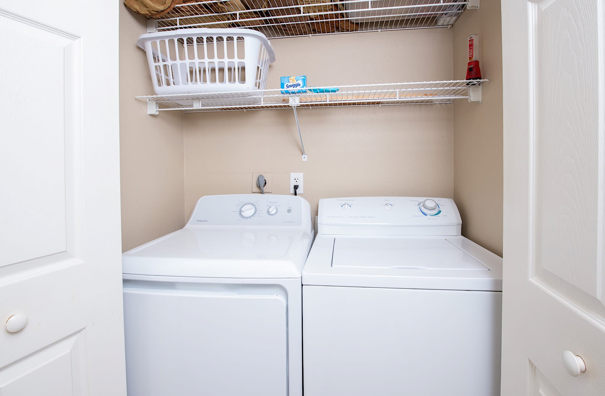 The hallway laundry closet offers a full size washer and dryer