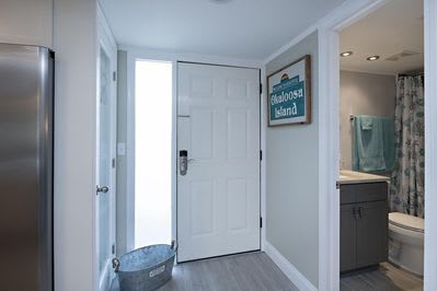 The entrance to the condo shows the first bathroom and the kitchen is nearby. 