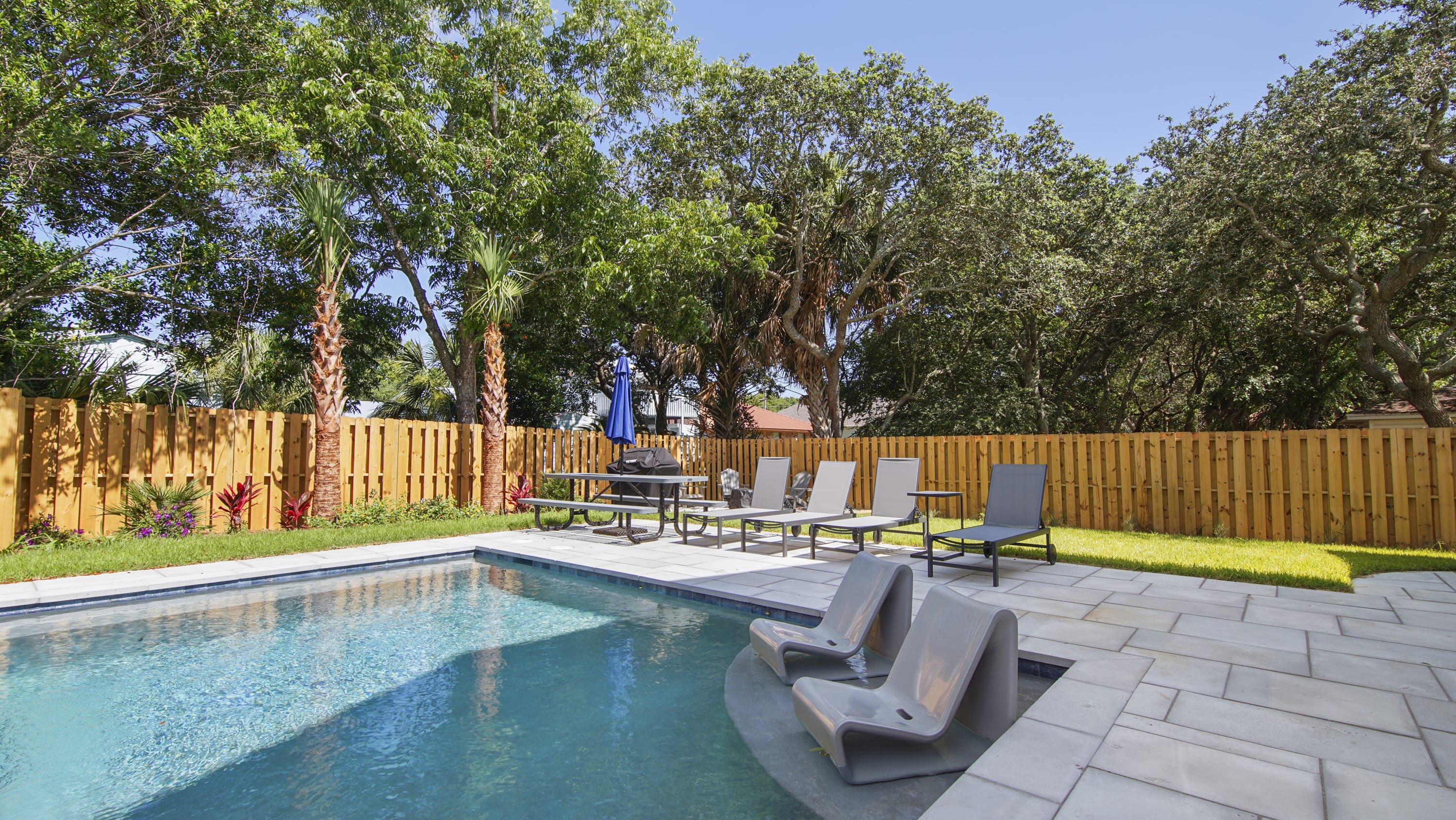 Pool with in pool seating and umbrella for pool and picnic table