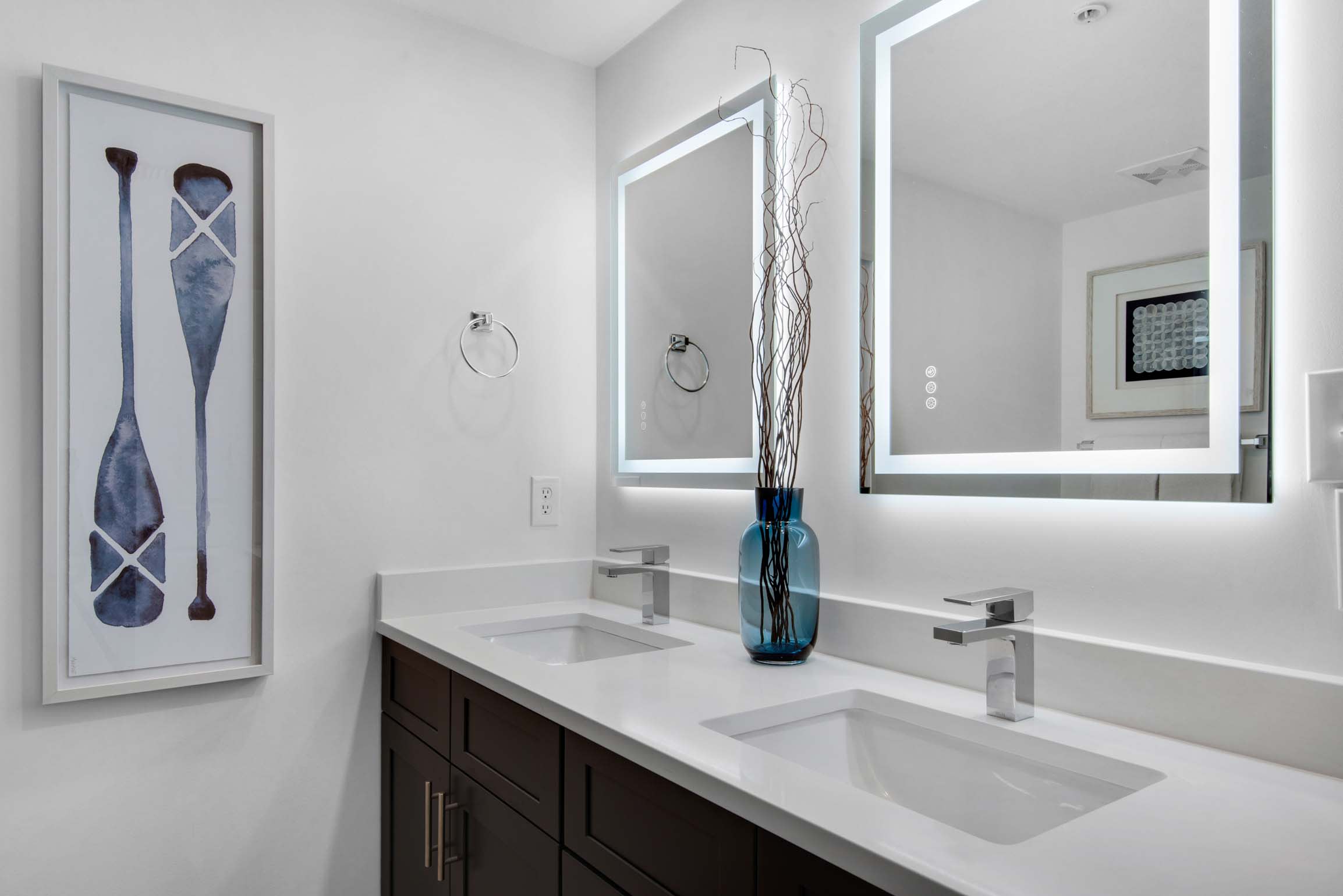 Dual sinks and lighted mirrors in primary bath. 