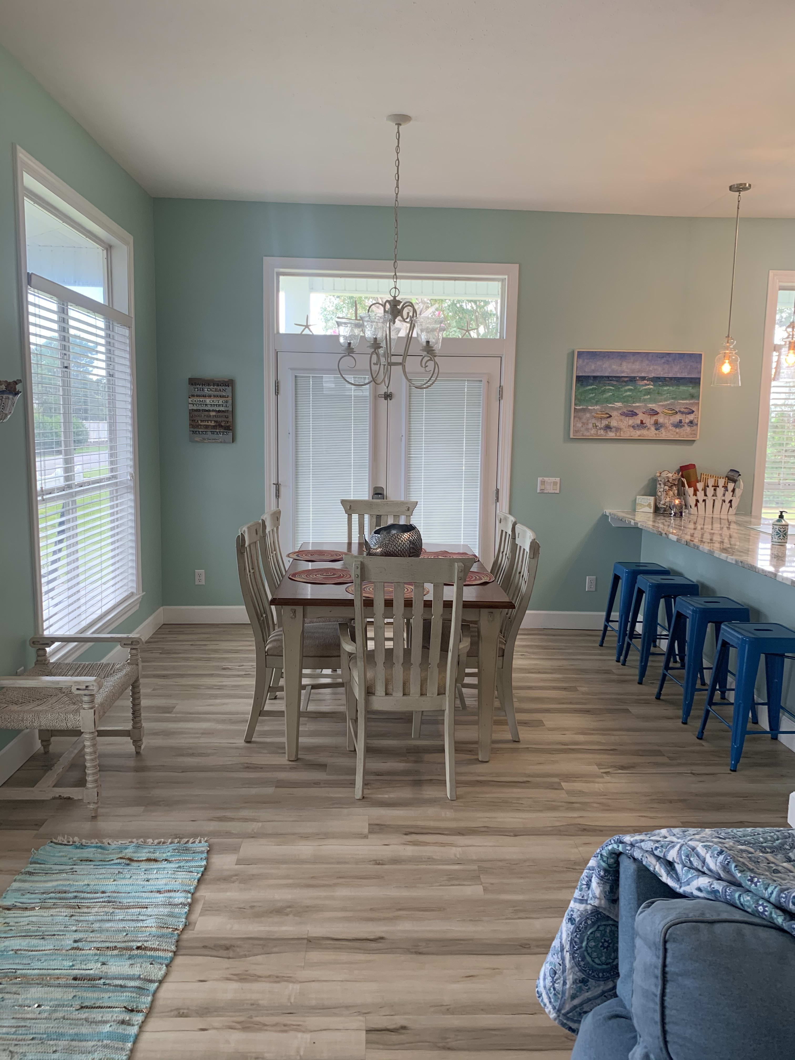 Dining room with seating at table and kitchen island.