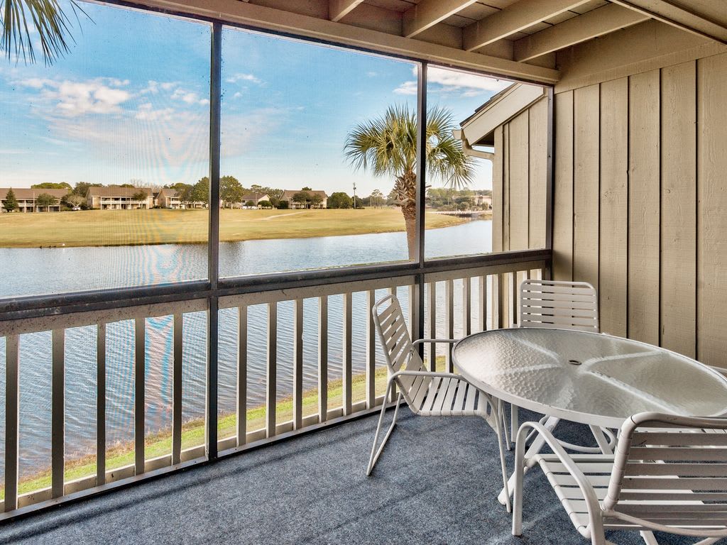 Dining deck off living area overlooks lake and golf course