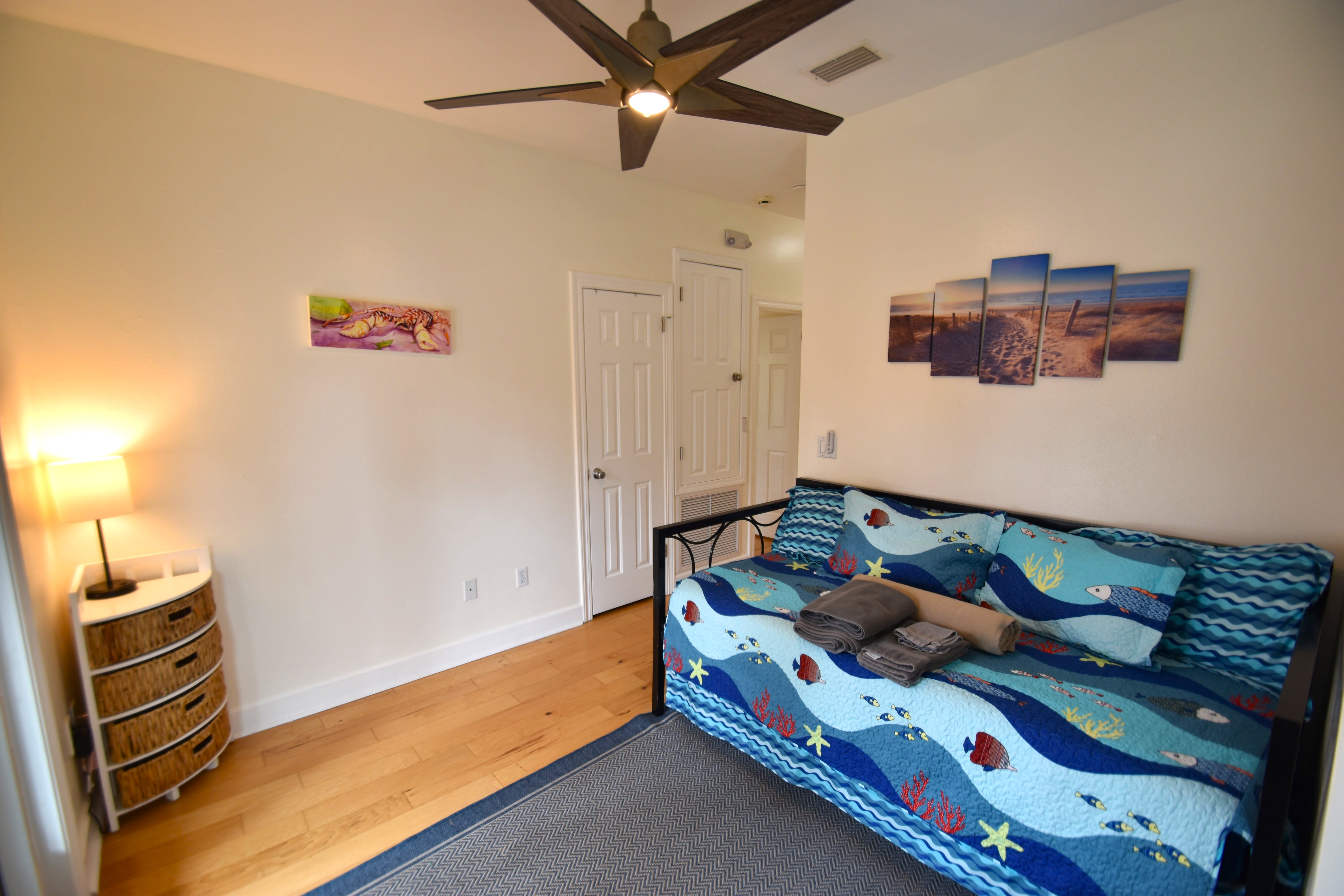 Second floor sitting room with twin daybed, pop-up trundle, and balcony access