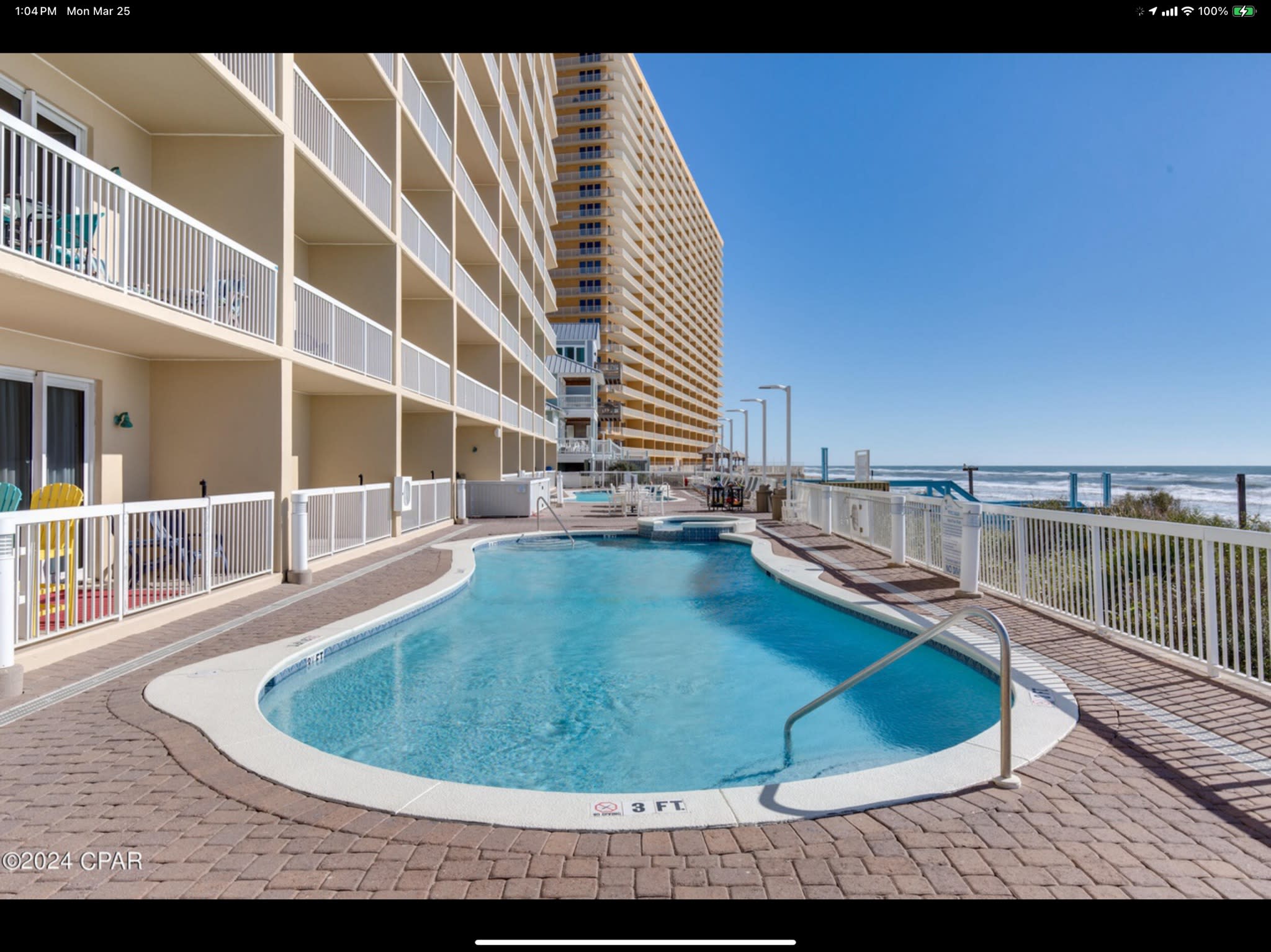 Oceanfront pool with lounge chairs, coastal views, and direct beach access