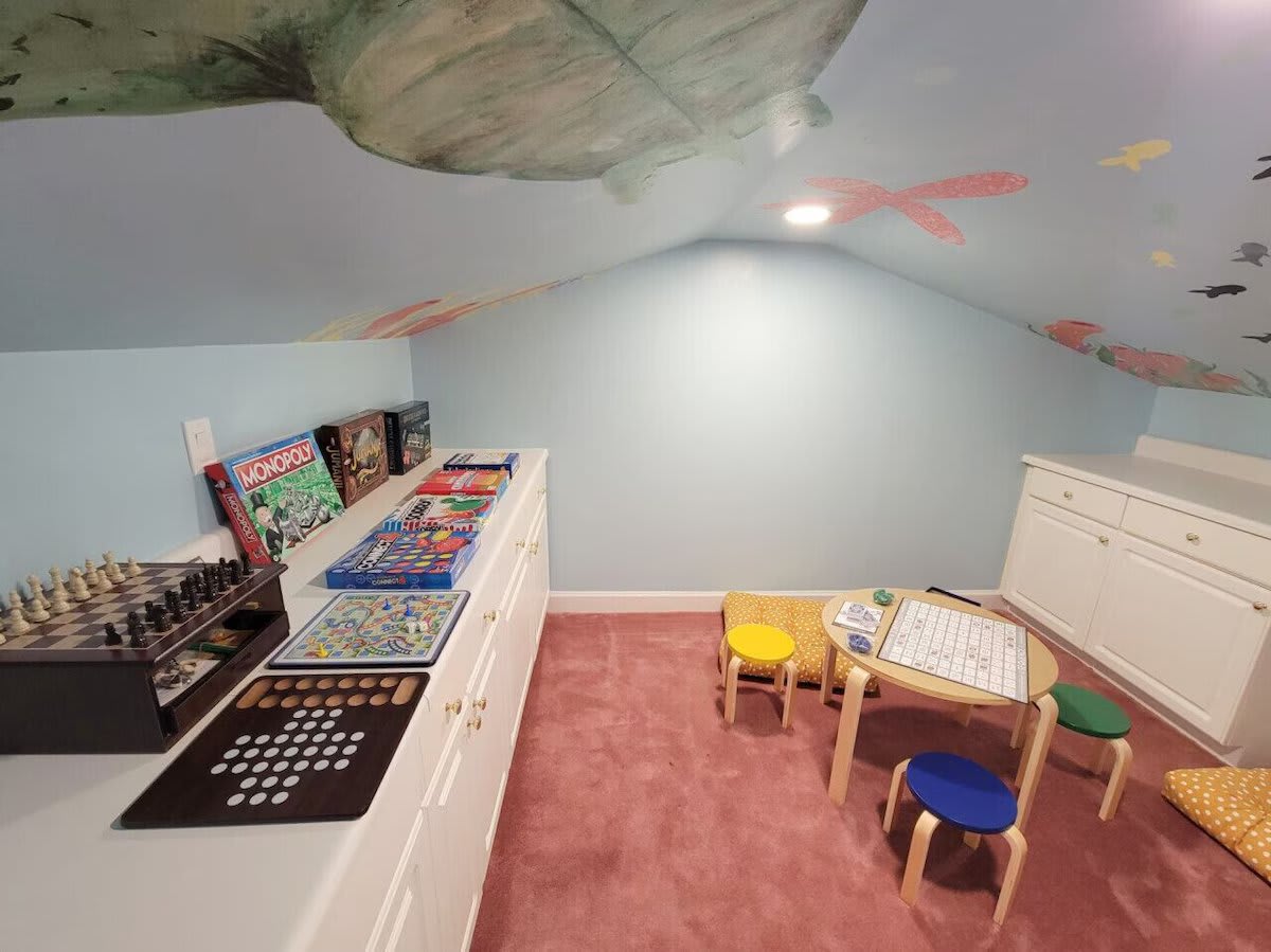 Under the sea adventure awaits! ðŸŒŠðŸ  Dive into fun with this playful kids' playroom, featuring a sea life mural on the ceiling, board games, a cozy kids' table &amp; stools. Perfect for endless hours of family fun.