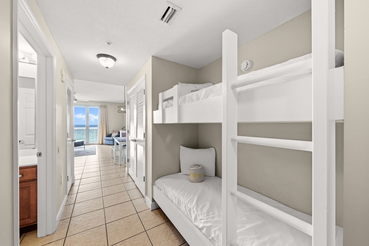 Hallway bunk beds with coastal views leading to bright oceanfront living area
