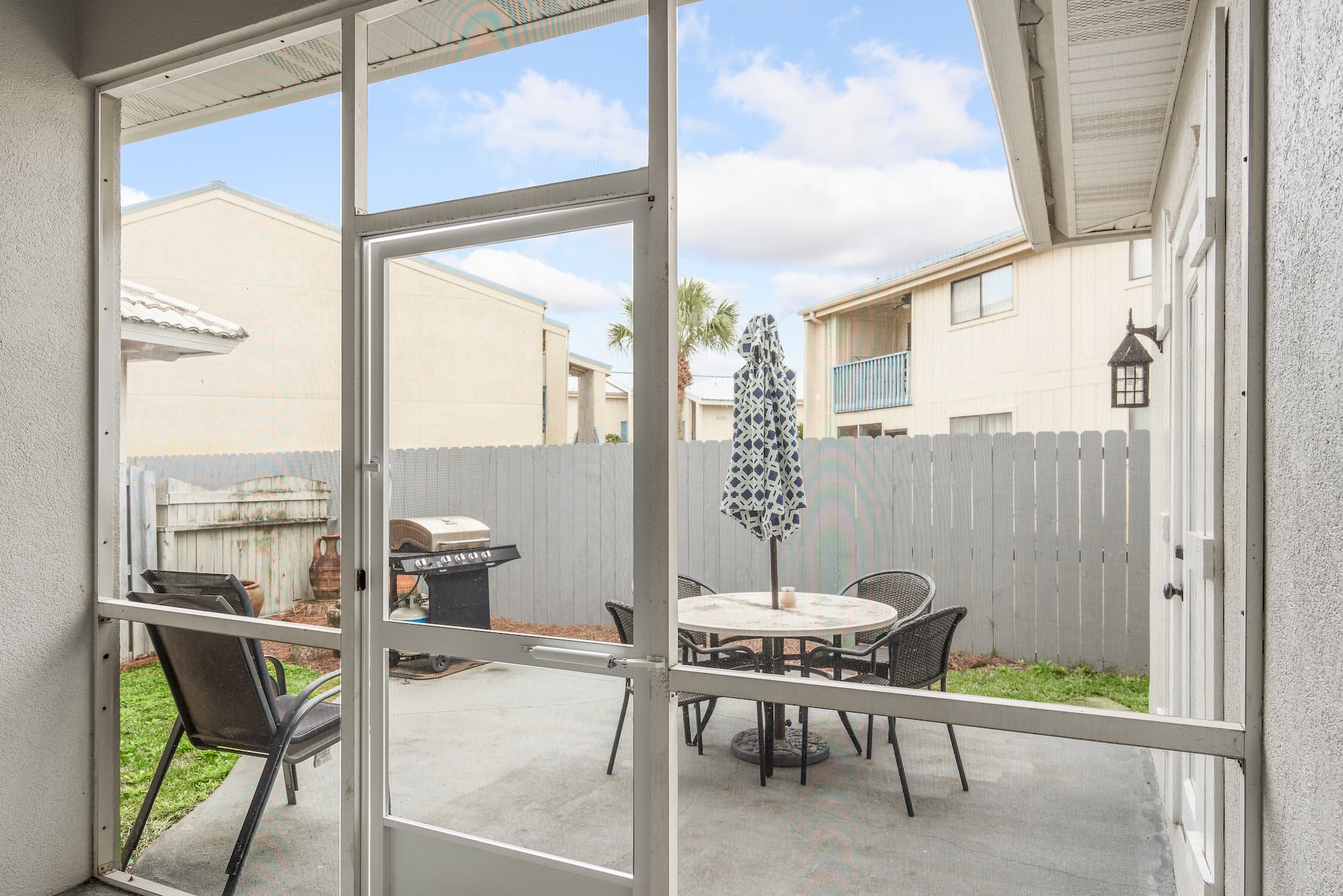 Outdoor patio area, fenced yard and gas grill