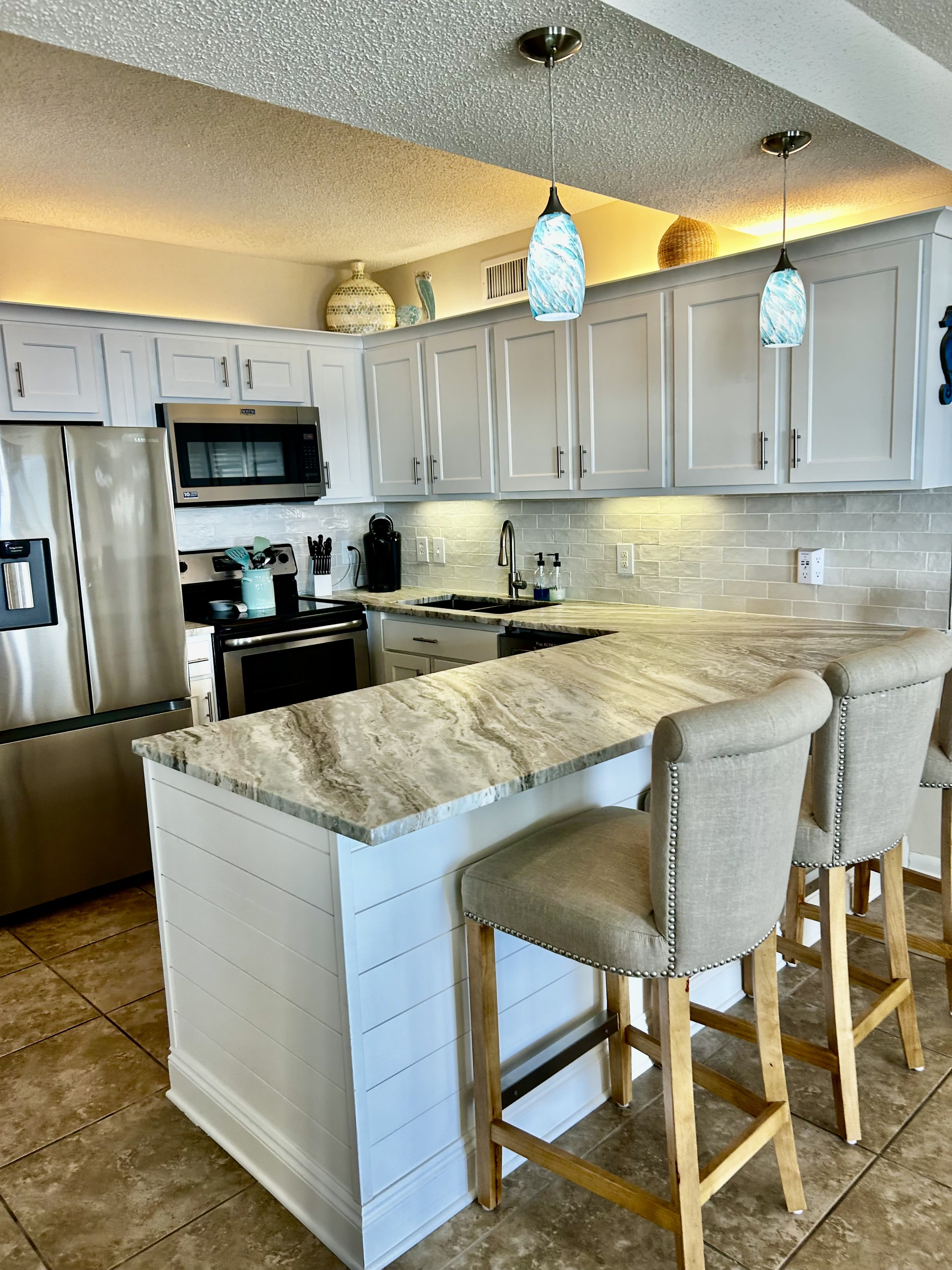 Kitchen with newly remodeled cabinets and granite counters. Bar seats 3.